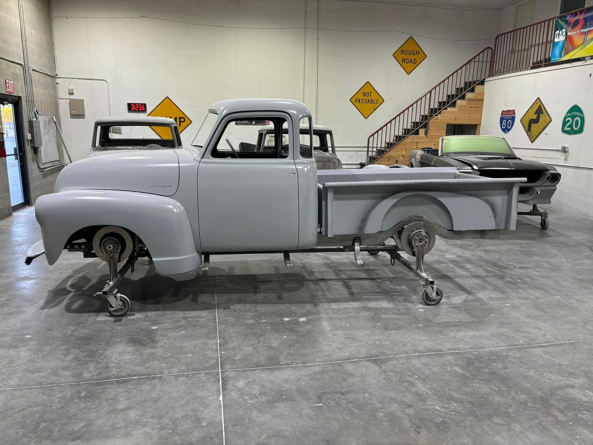 A white truck is sitting on a concrete floor in a garage.
