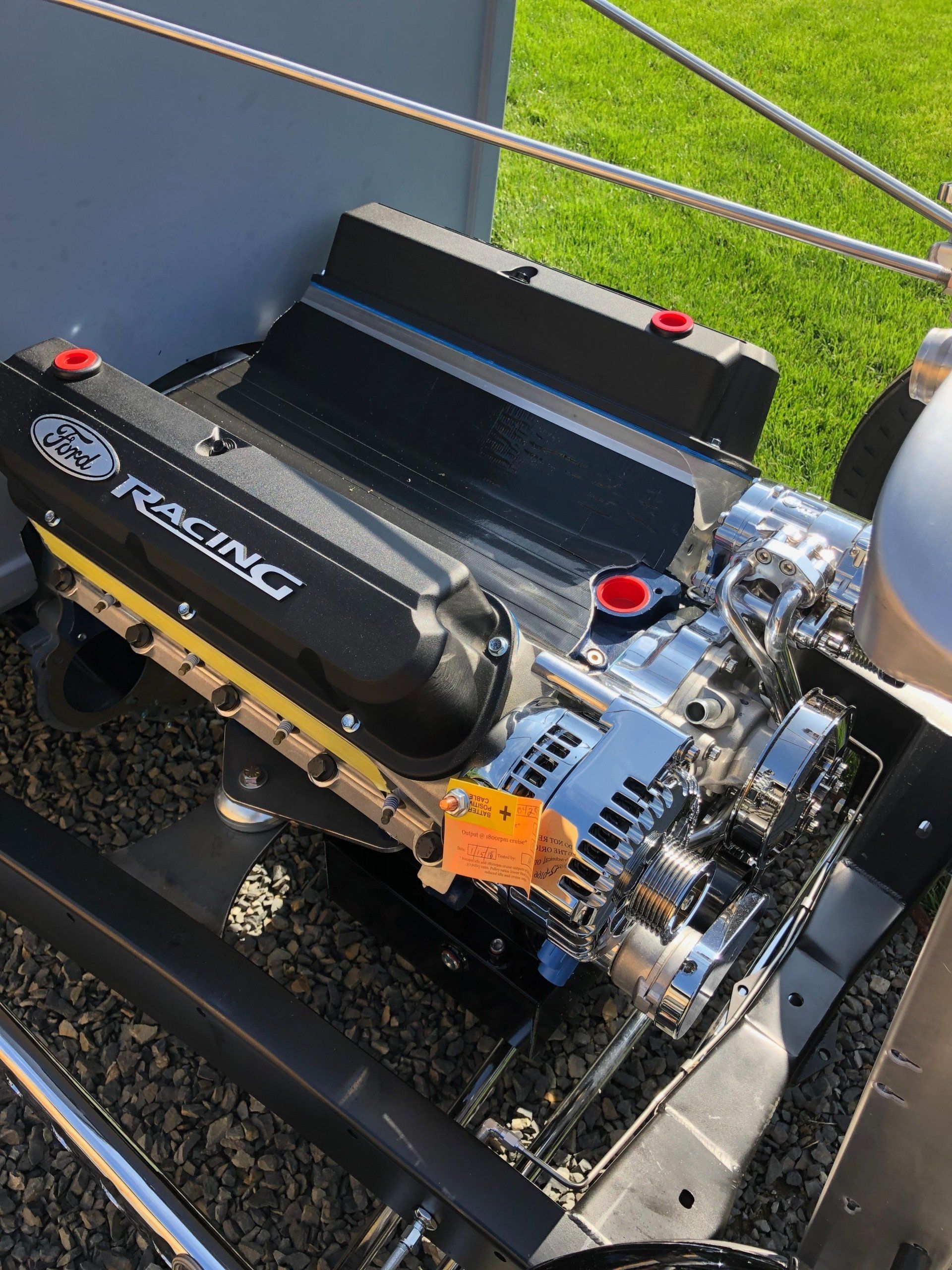 A ford racing engine is sitting on top of a trailer.