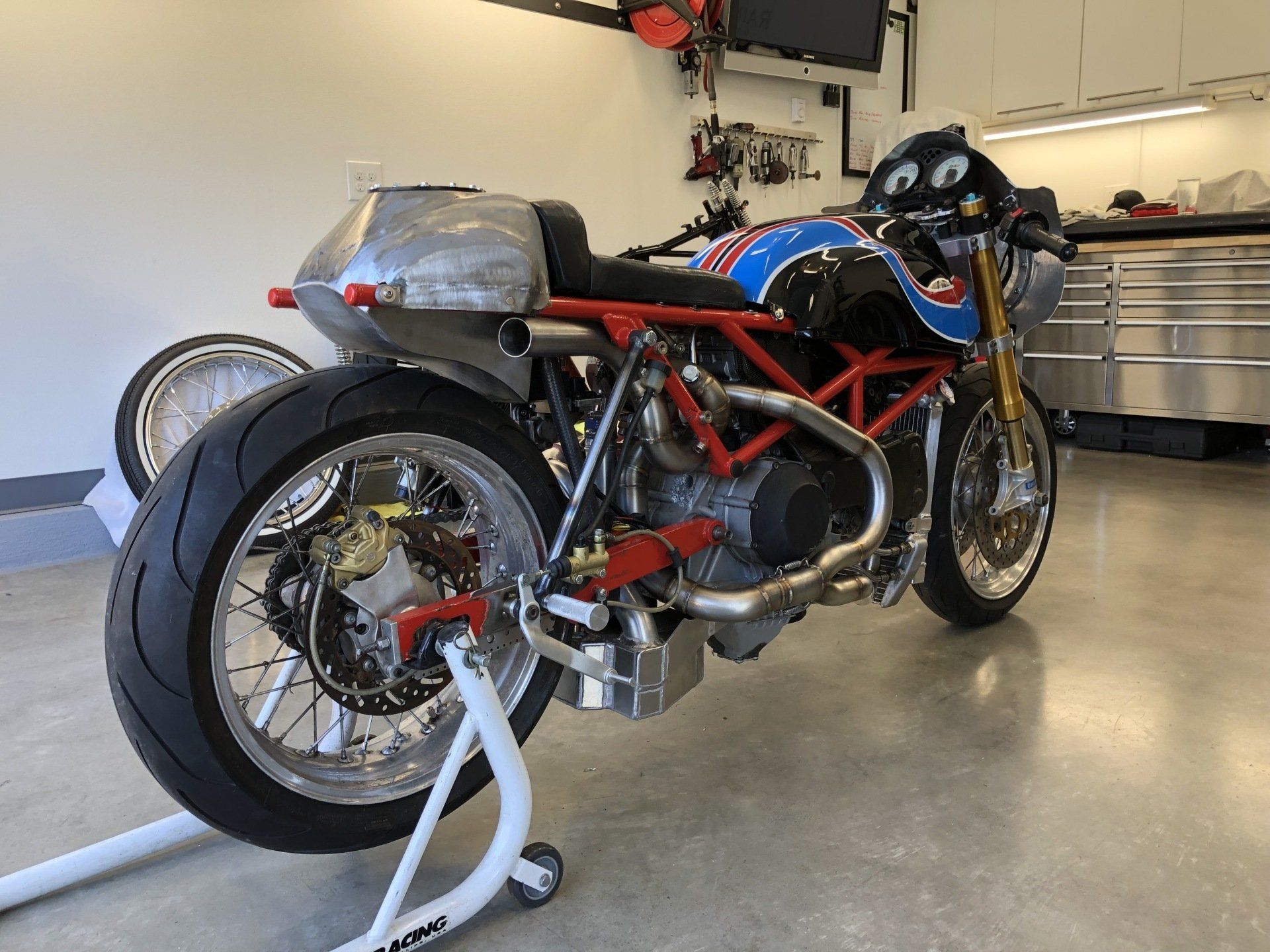 A blue and red motorcycle is parked in a garage