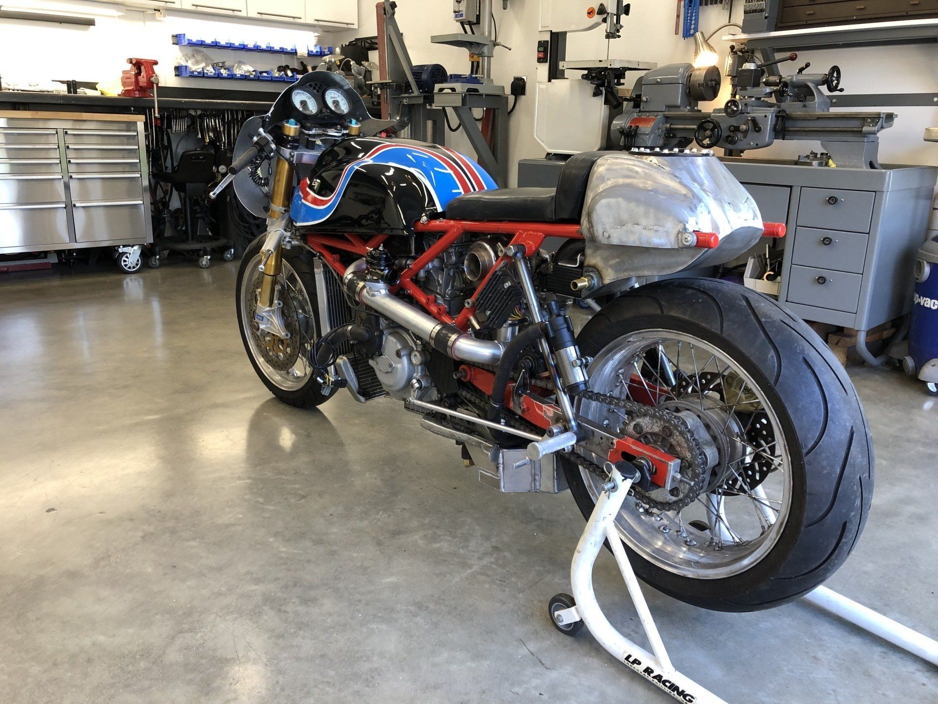 A motorcycle is sitting on a stand in a garage.