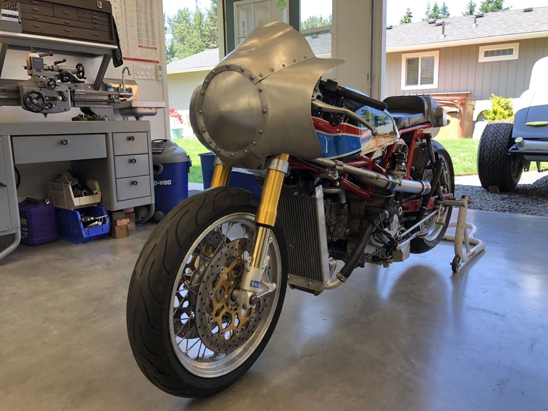 A motorcycle is sitting on a stand in a garage.
