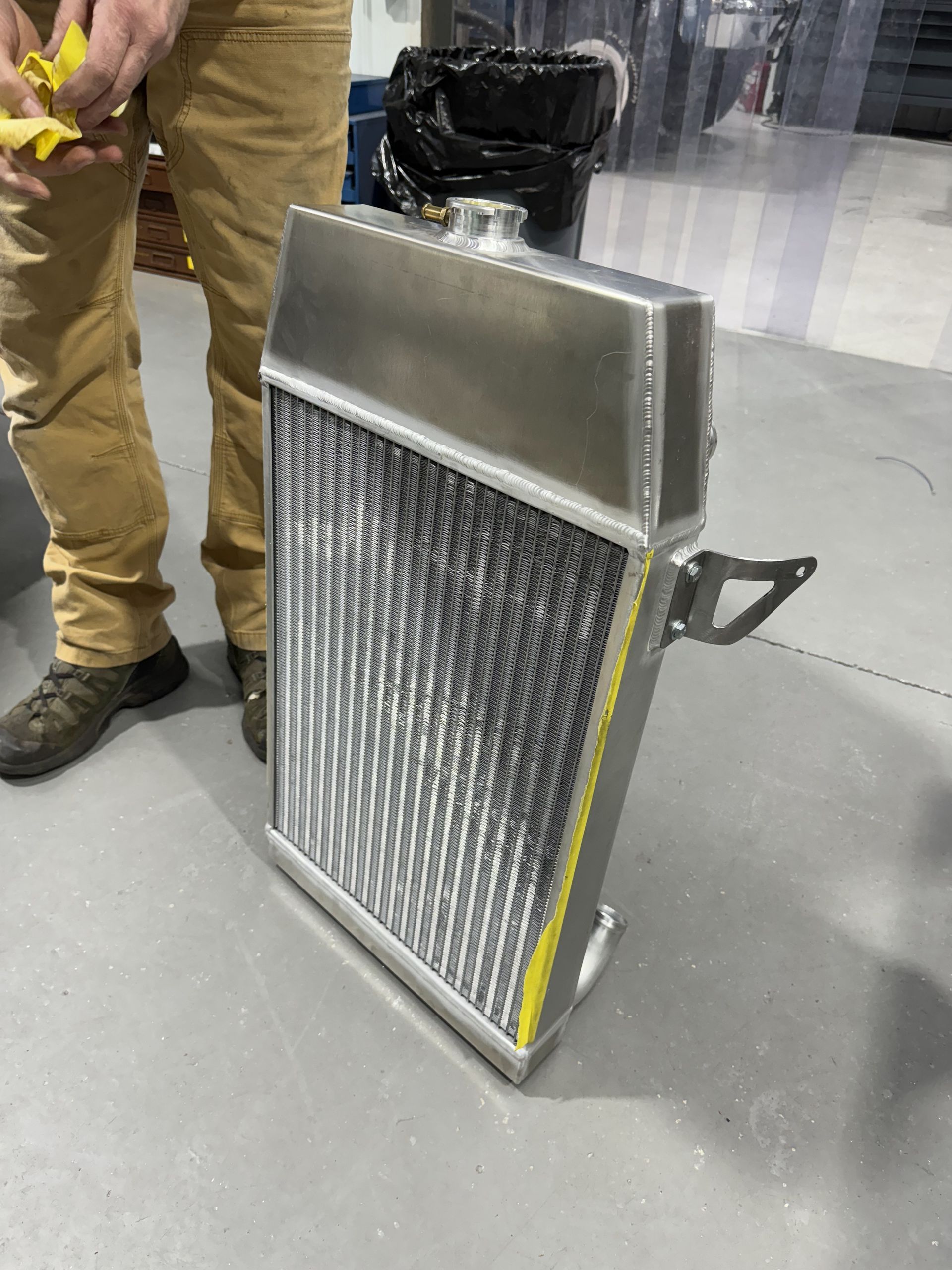 A man is standing next to a stainless steel radiator