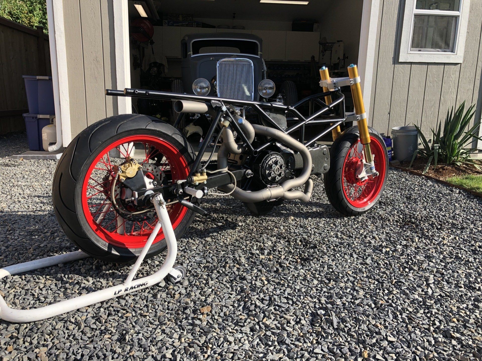 A motorcycle is parked in front of a garage.