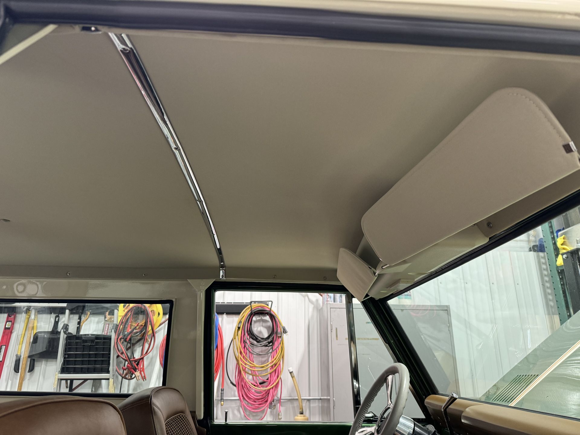 The ceiling of a car with a tv mounted to it.