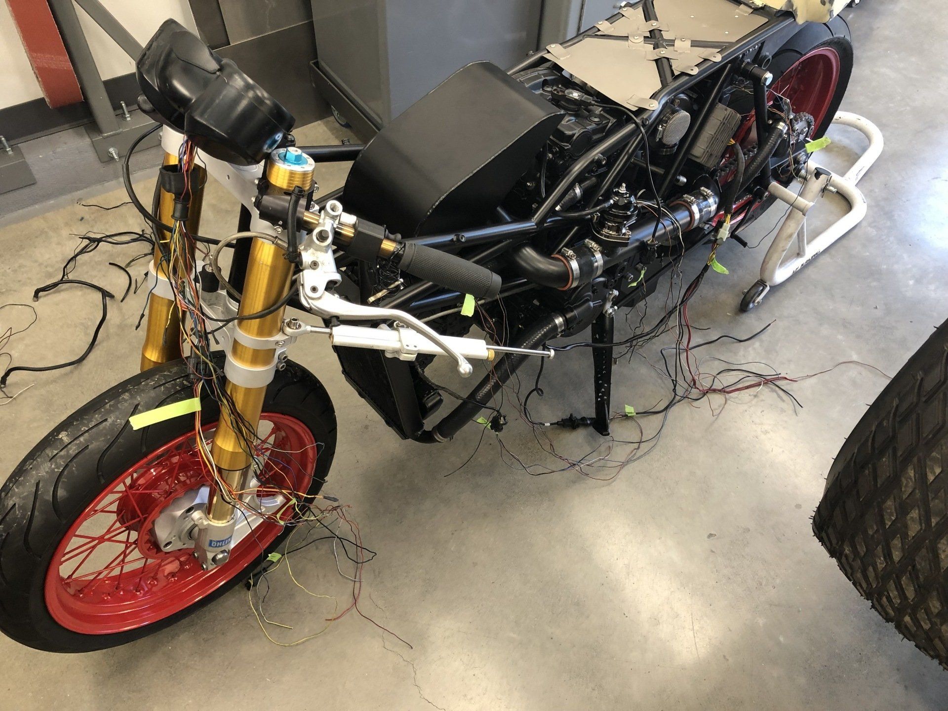 A motorcycle is sitting on a concrete floor in a garage.