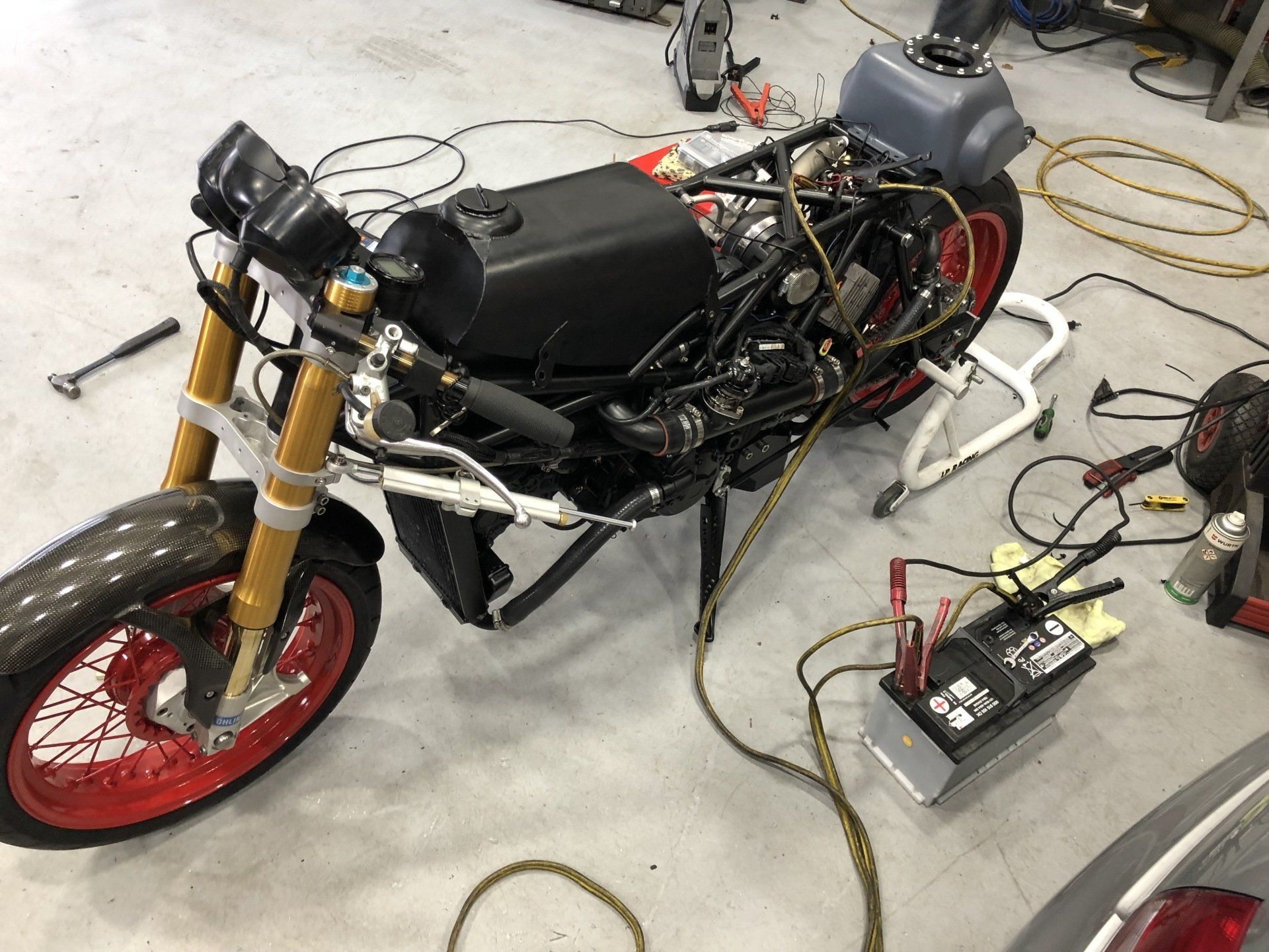 A motorcycle is being worked on in a garage.