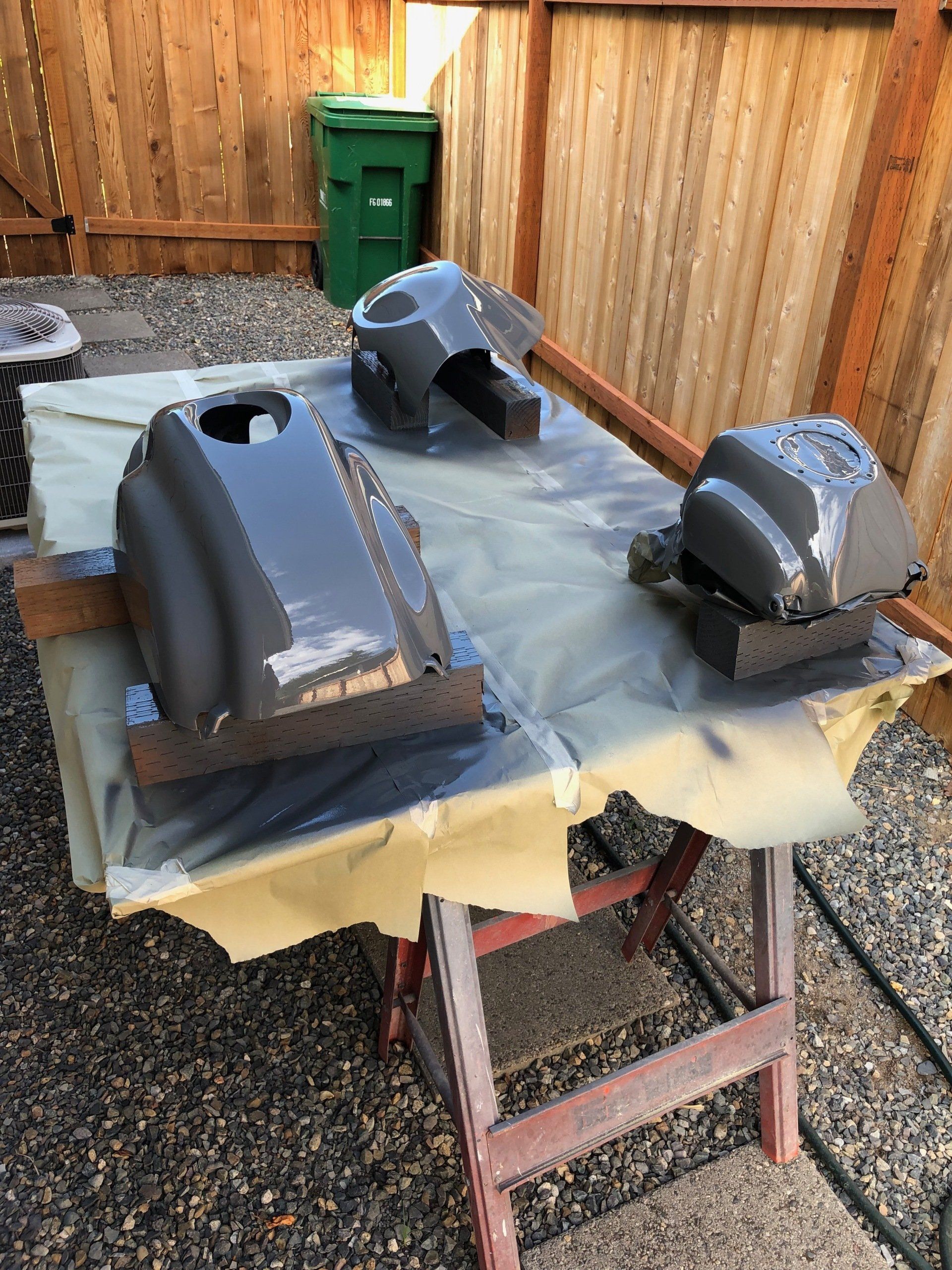 Two pieces of metal are sitting on top of a table covered in plastic.