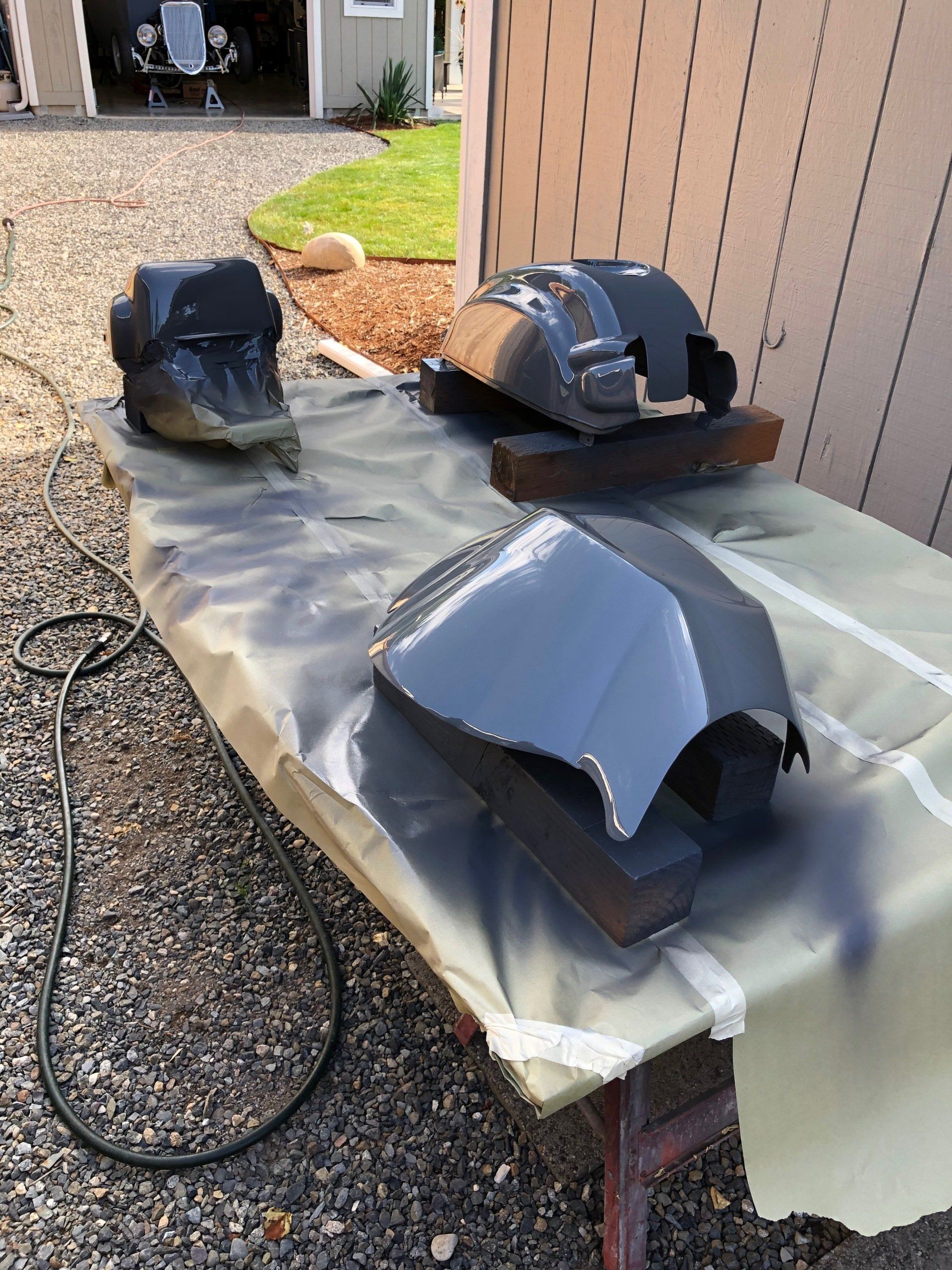 Two pieces of metal are sitting on a table covered in plastic.