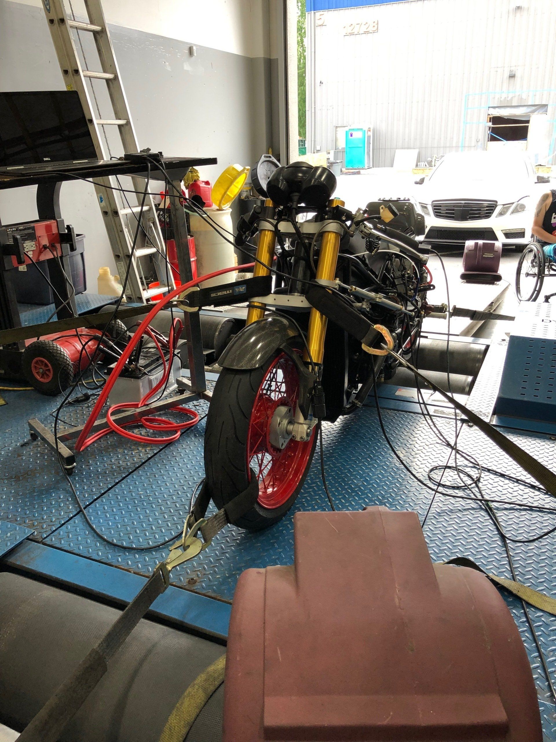 A motorcycle is being worked on in a garage.