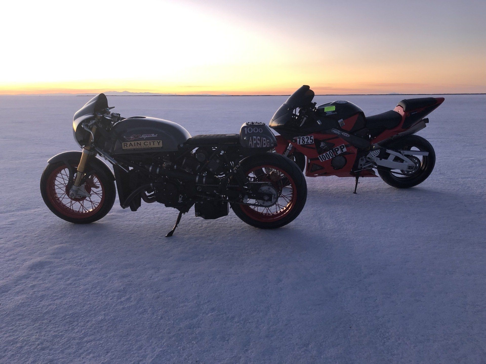 Two motorcycles are parked next to each other in the snow.