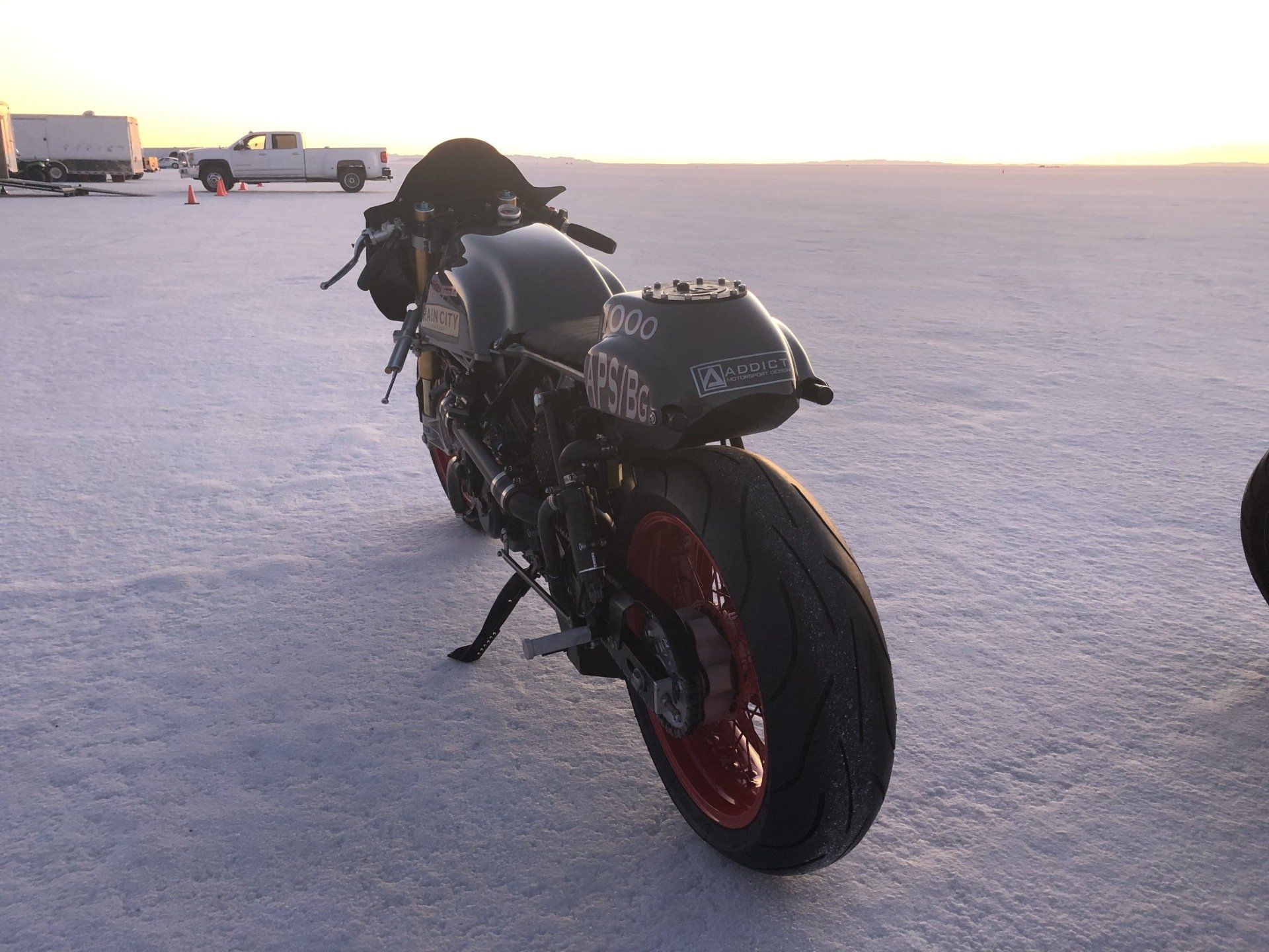 A black motorcycle is parked on a snowy field