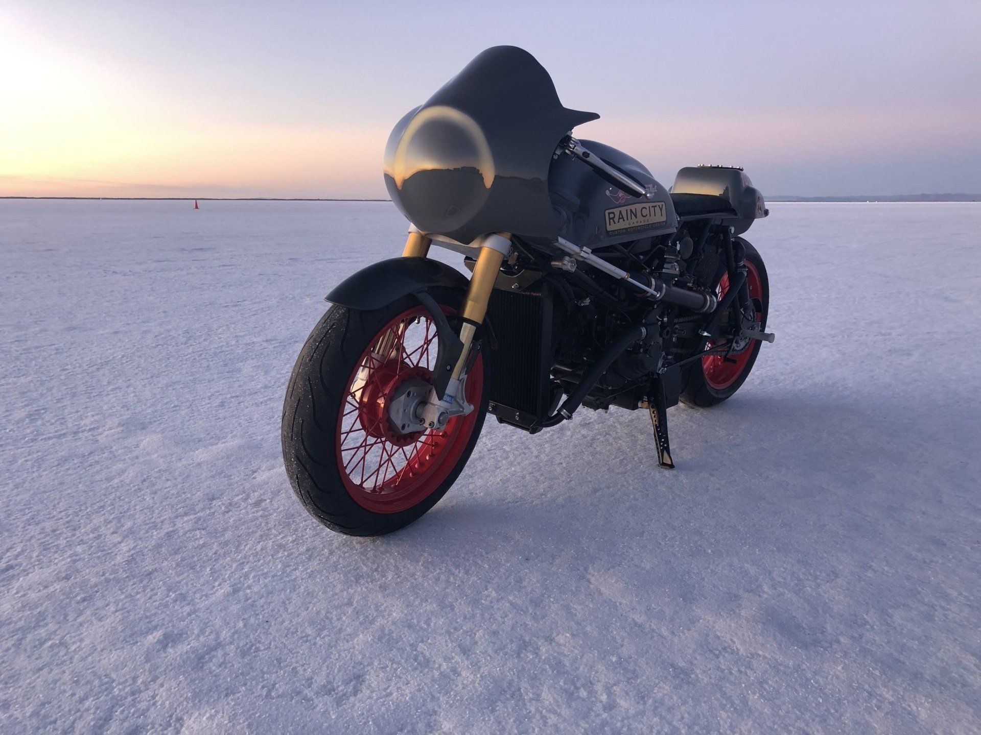 A black motorcycle is parked on a snowy field