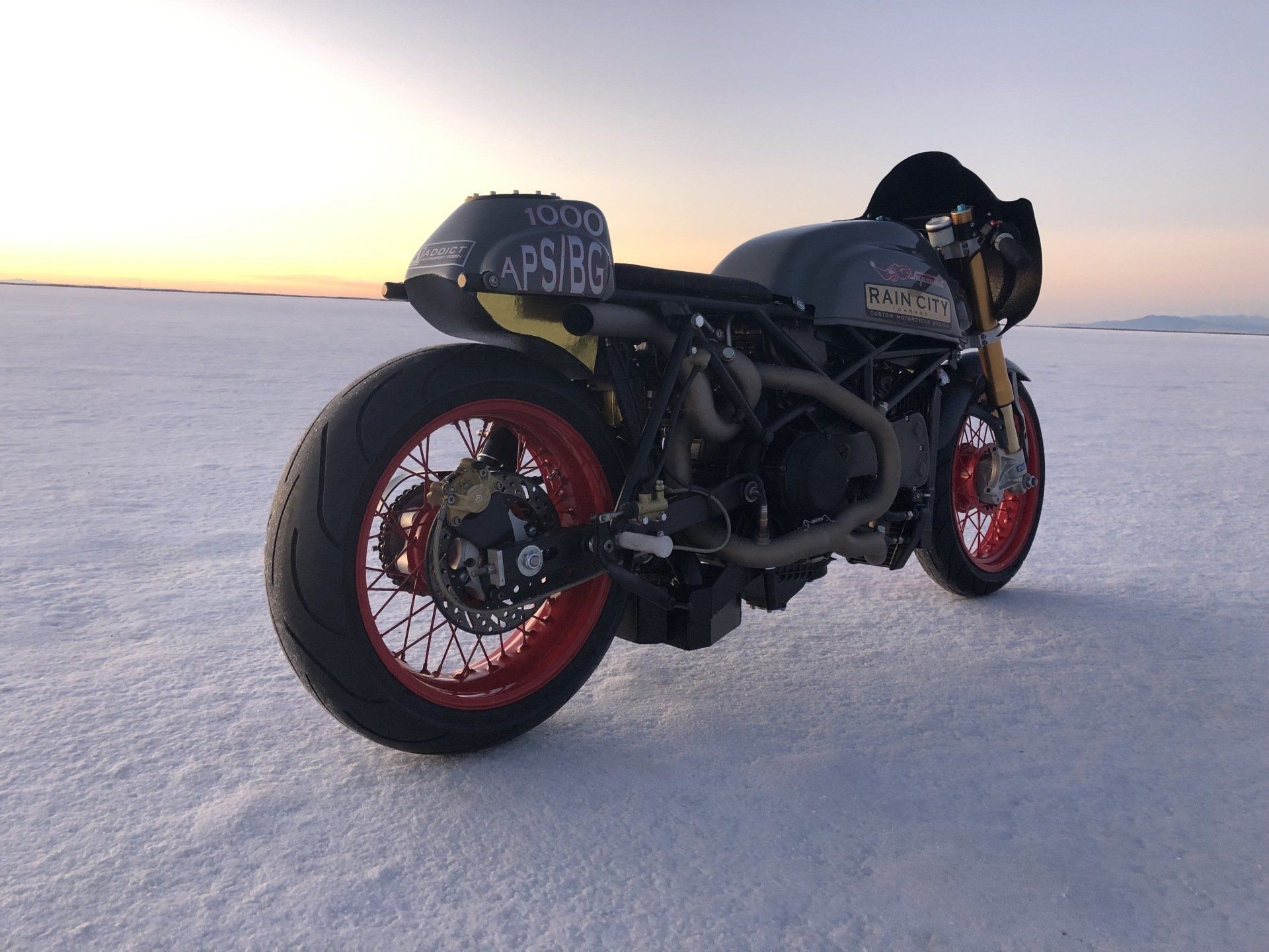 A motorcycle with a license plate that says aps188 is parked in the snow