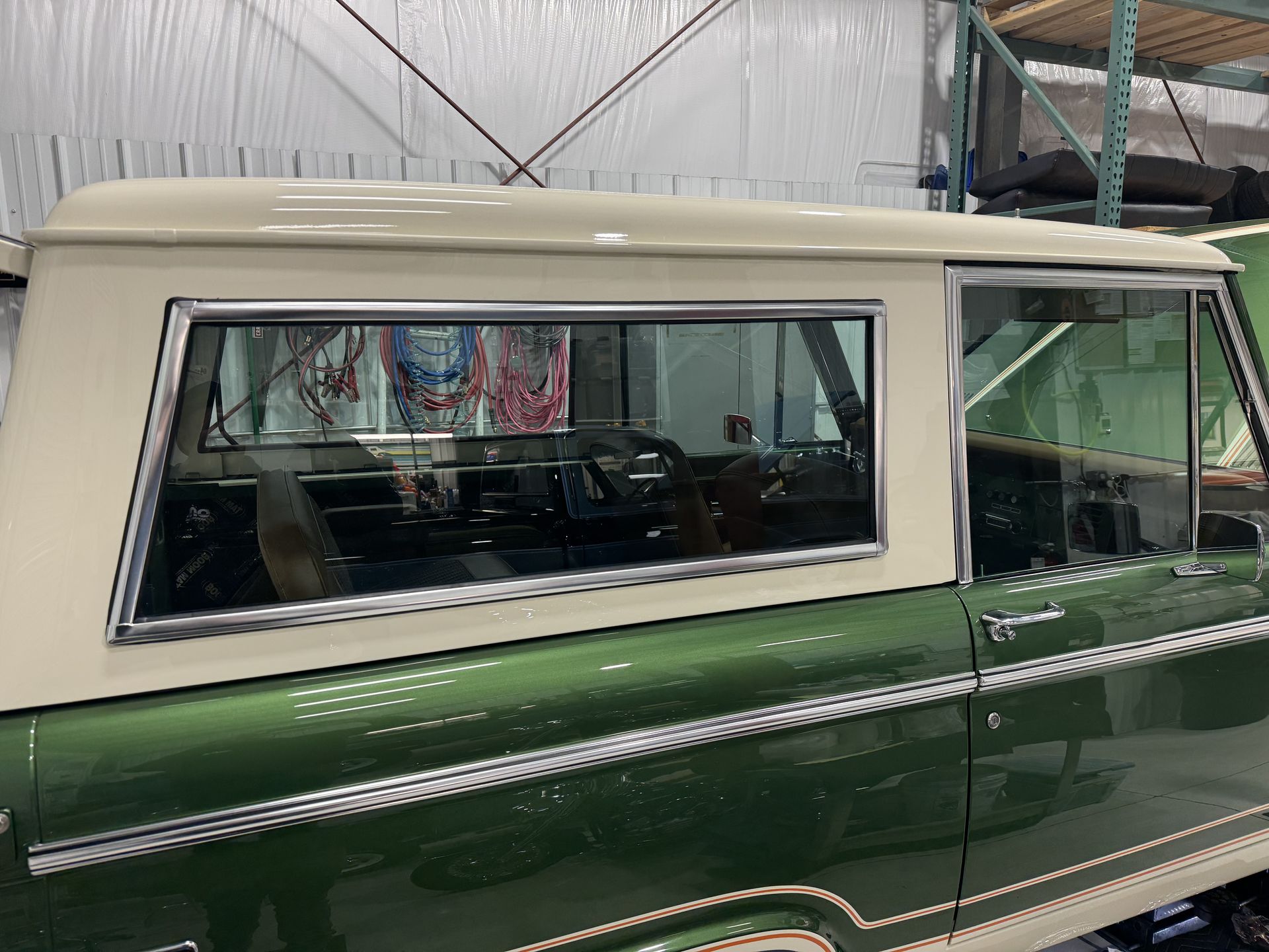 A green and white truck is parked in a warehouse.