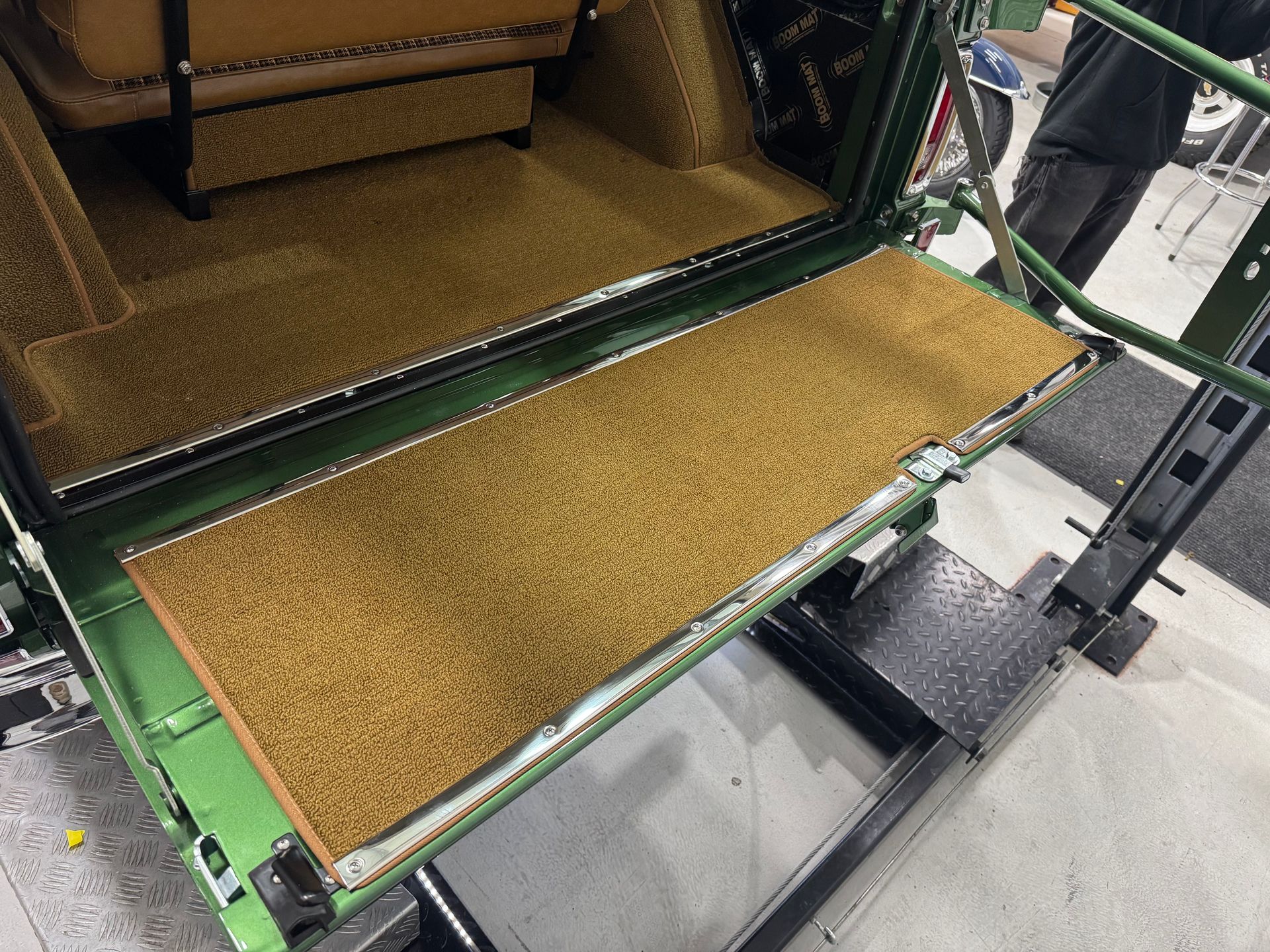 A green car with a brown mat on the bottom of it