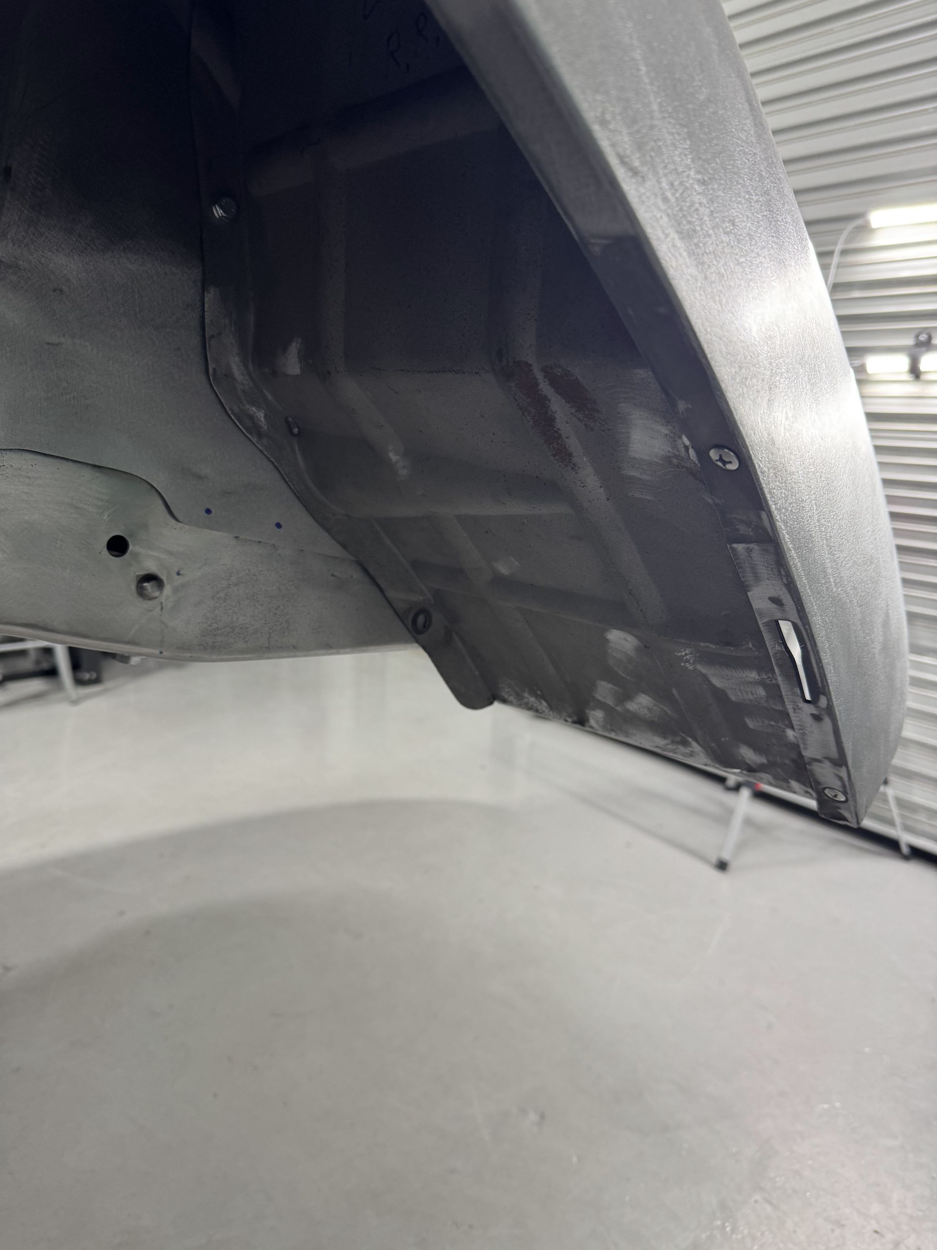 A close up of the underside of a car in a garage.