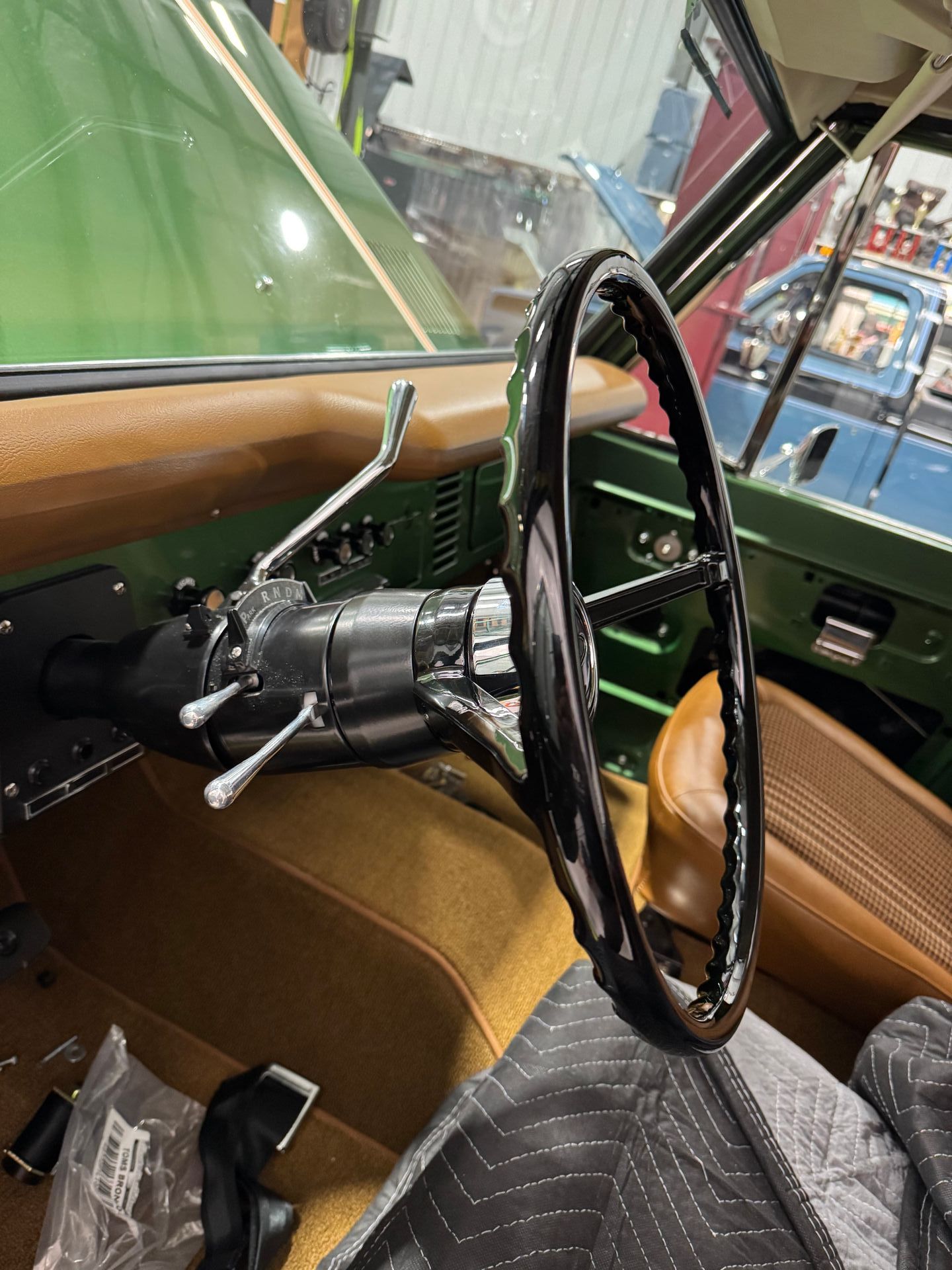 The inside of a green car with a black steering wheel