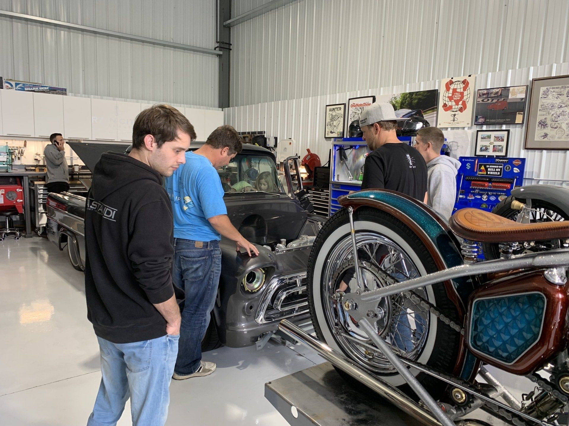 A group of men are working on a motorcycle in a garage.