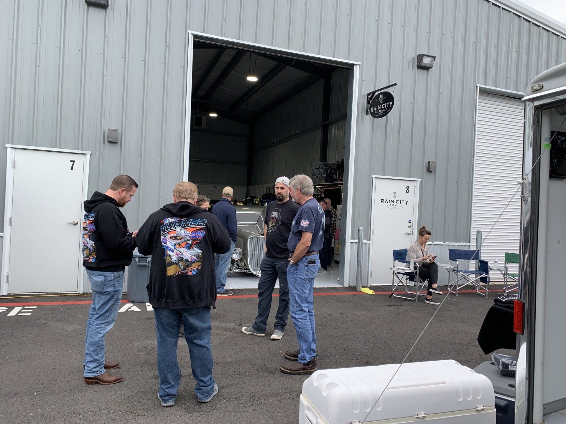 A group of men are standing outside of a building talking to each other