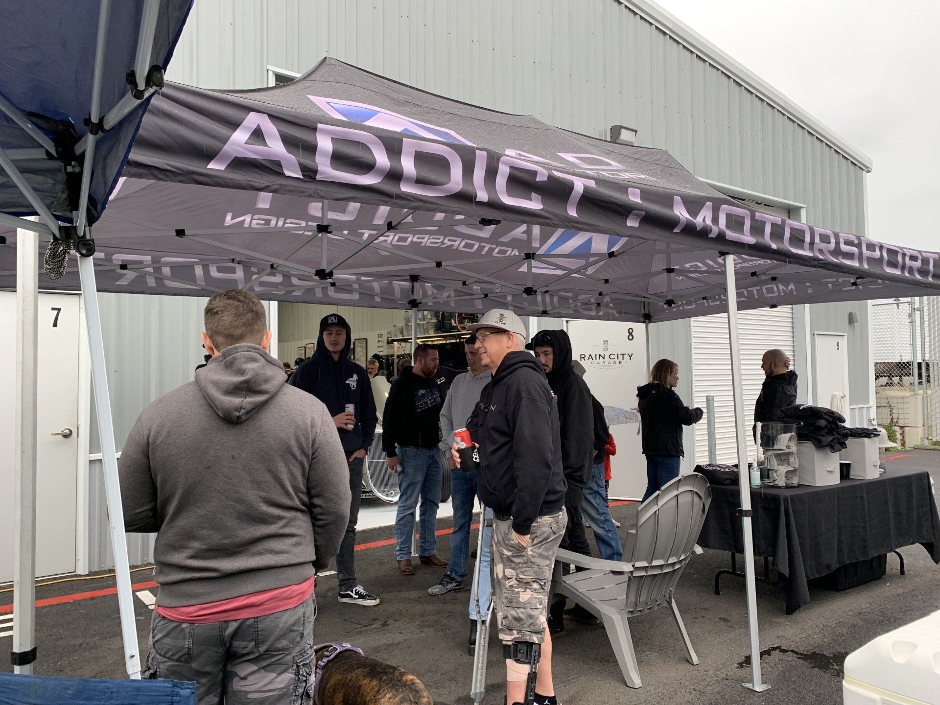 A group of people are standing under a tent in front of a building.
