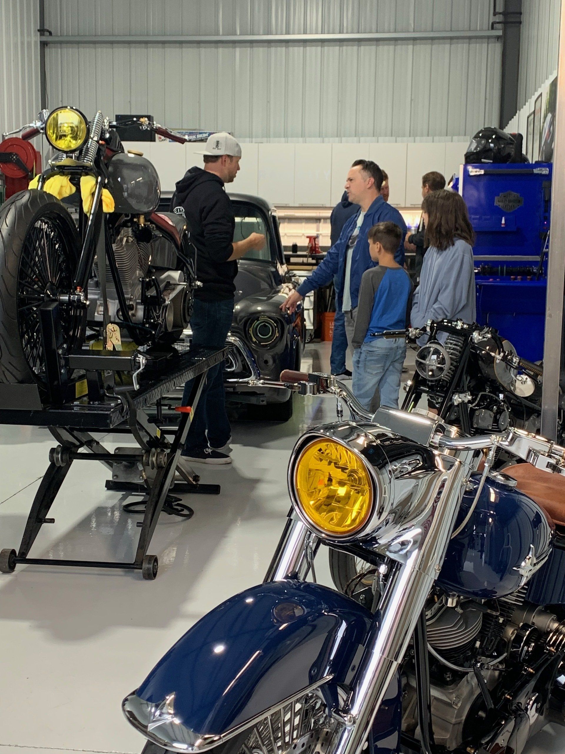 A group of people are working on a motorcycle in a garage.