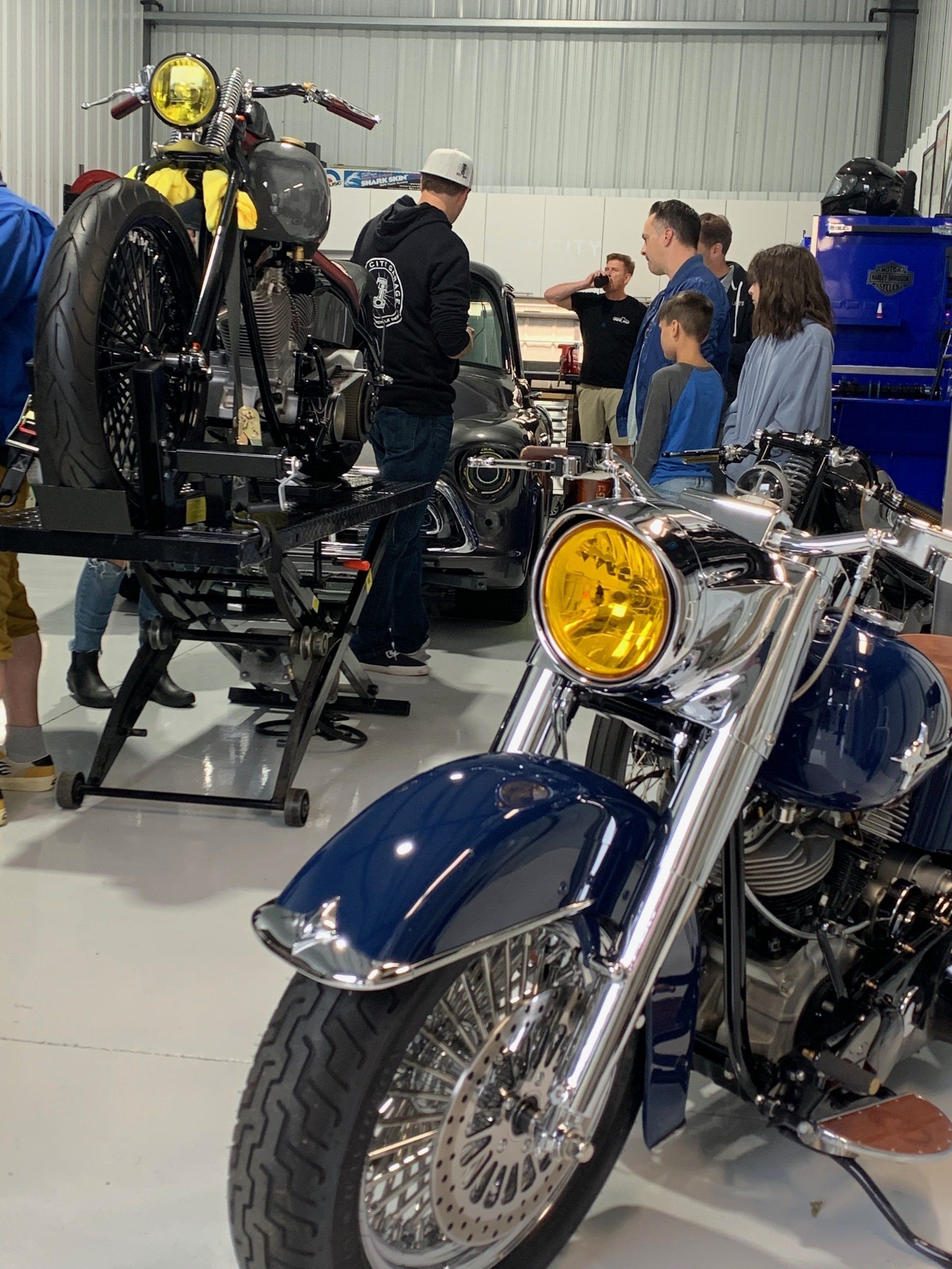 A group of people are working on a motorcycle in a garage.