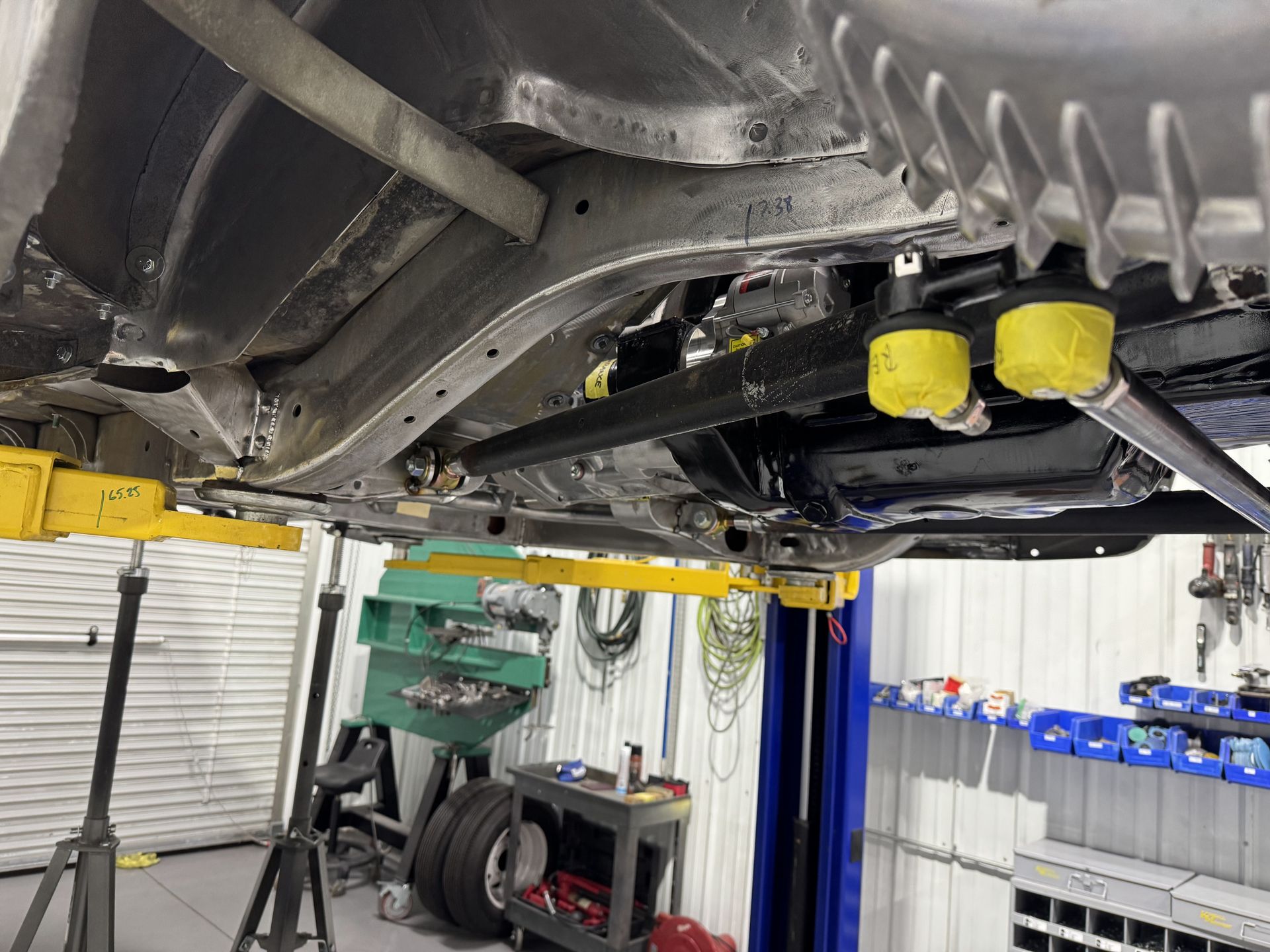 A car is sitting on a lift in a garage.