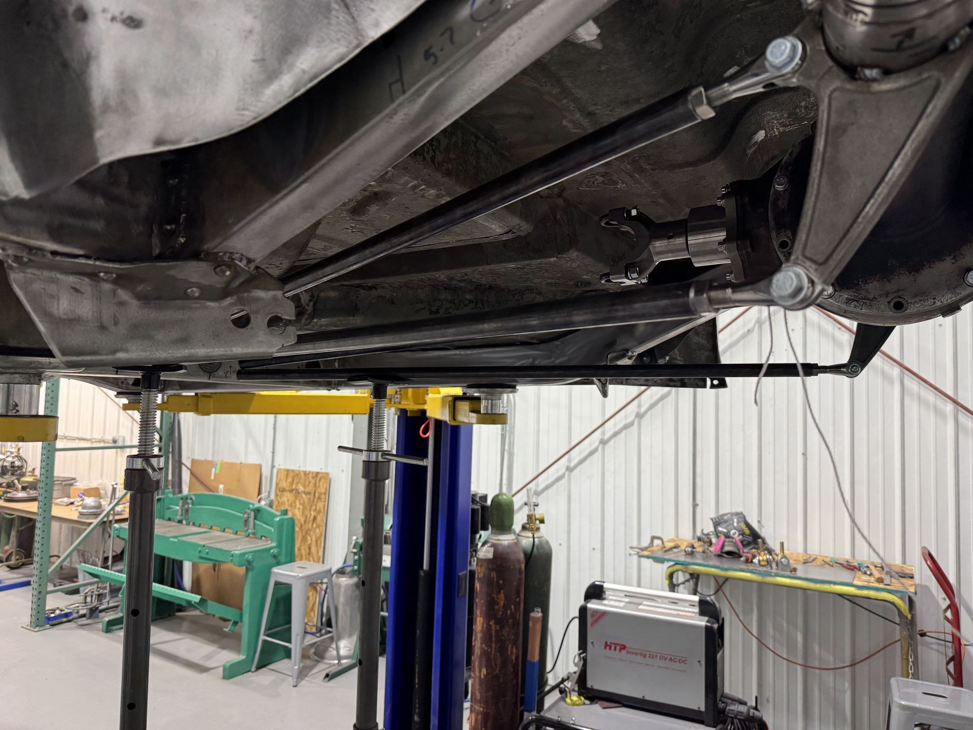 A car is sitting on a lift in a garage.