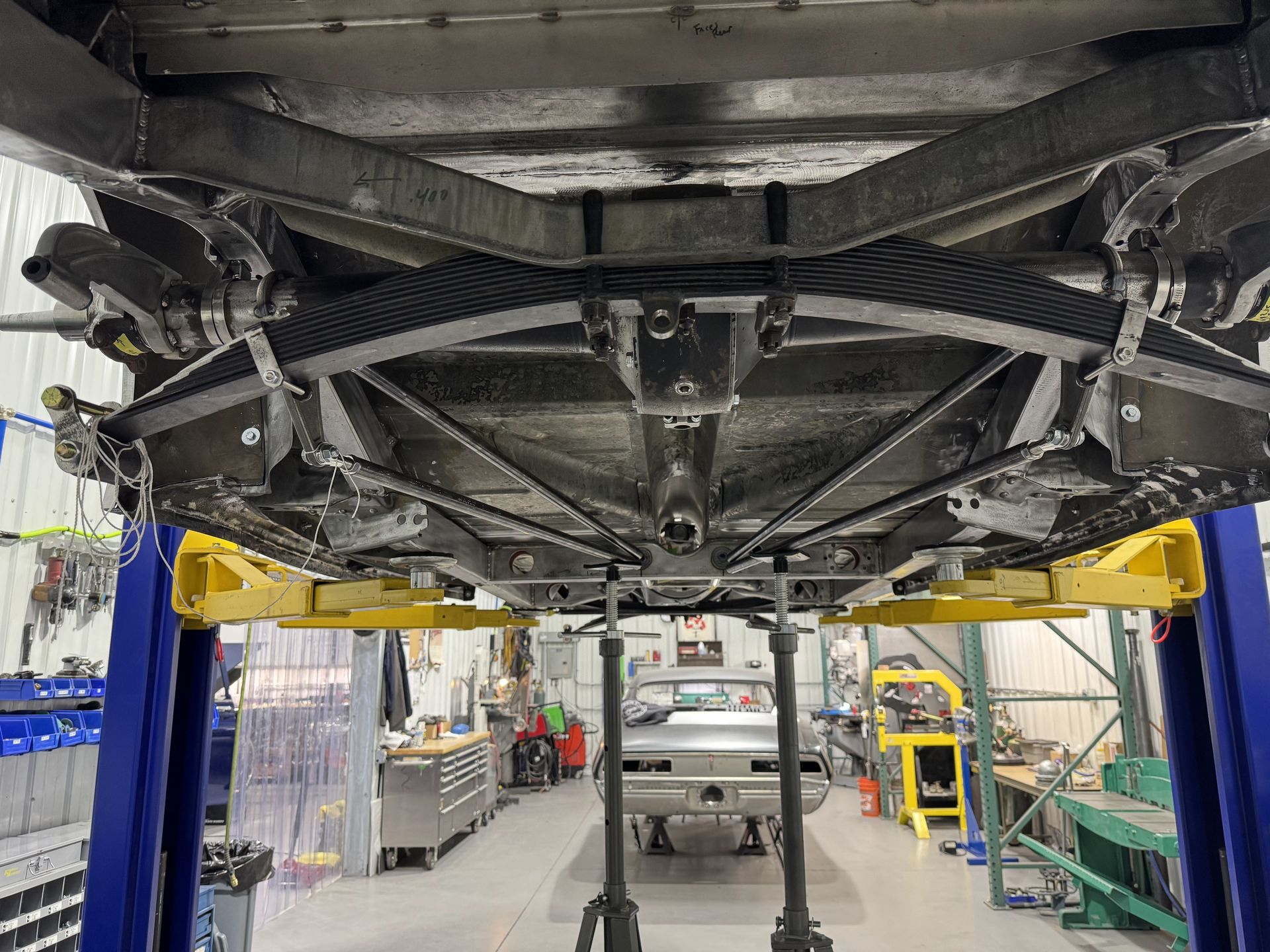 A car is sitting on a lift in a garage.