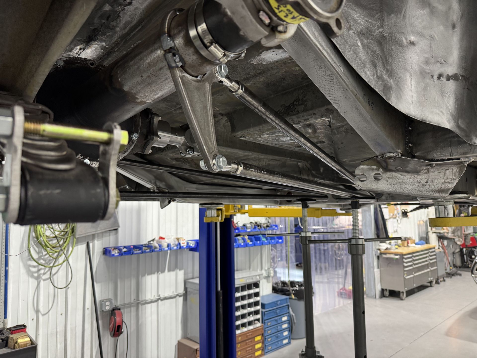A car is sitting on a lift in a garage.