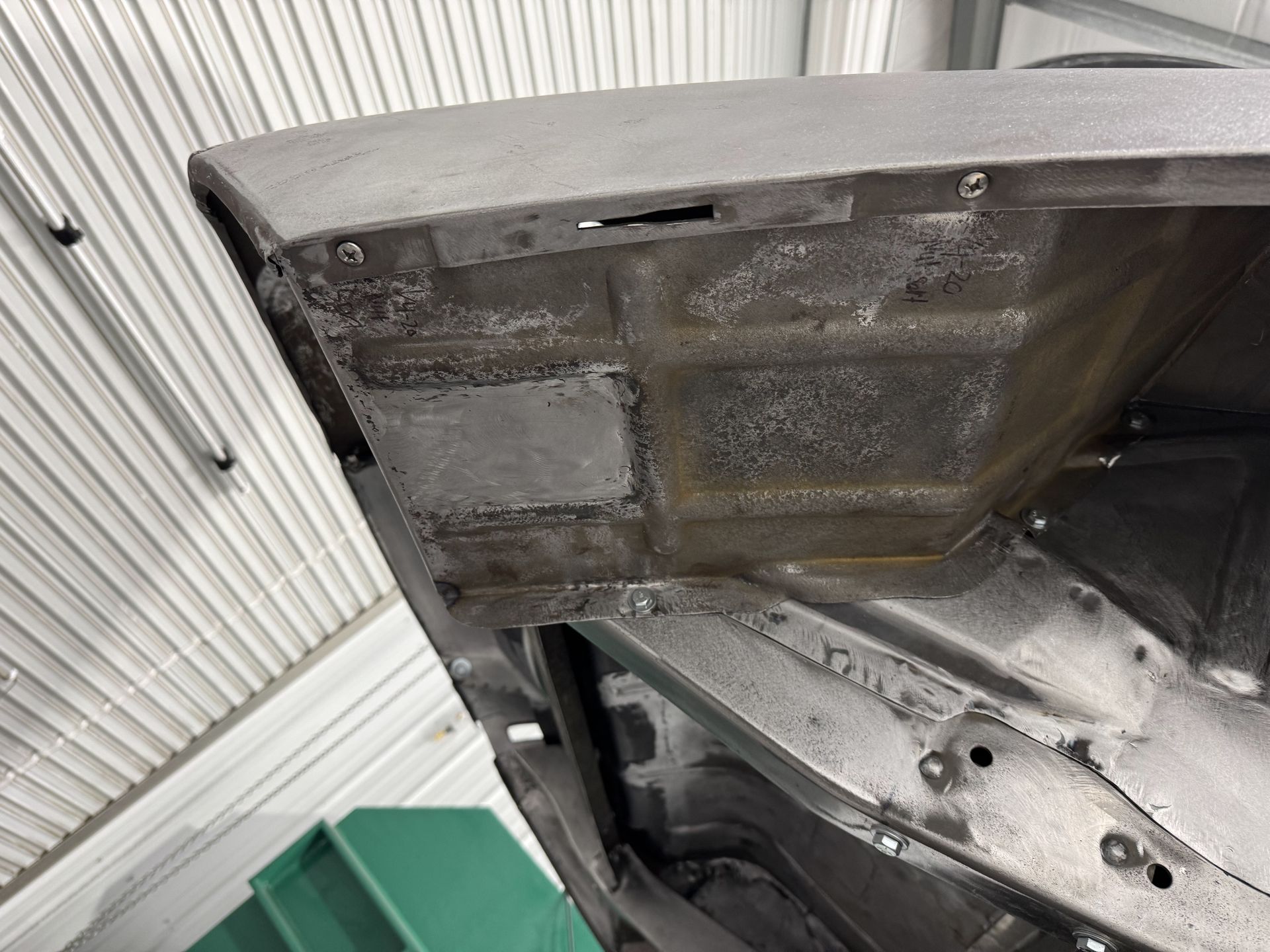 A close up of a car hood in a garage.