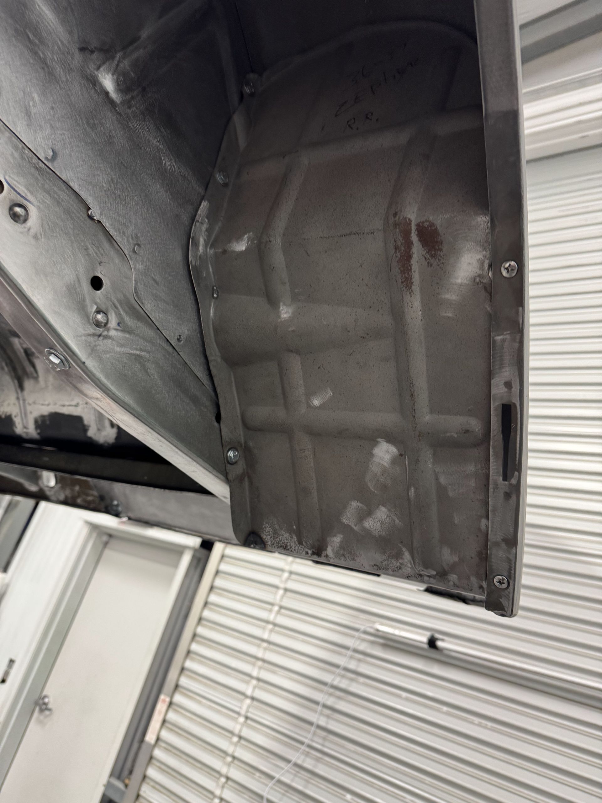 A car is sitting on a lift in a garage.