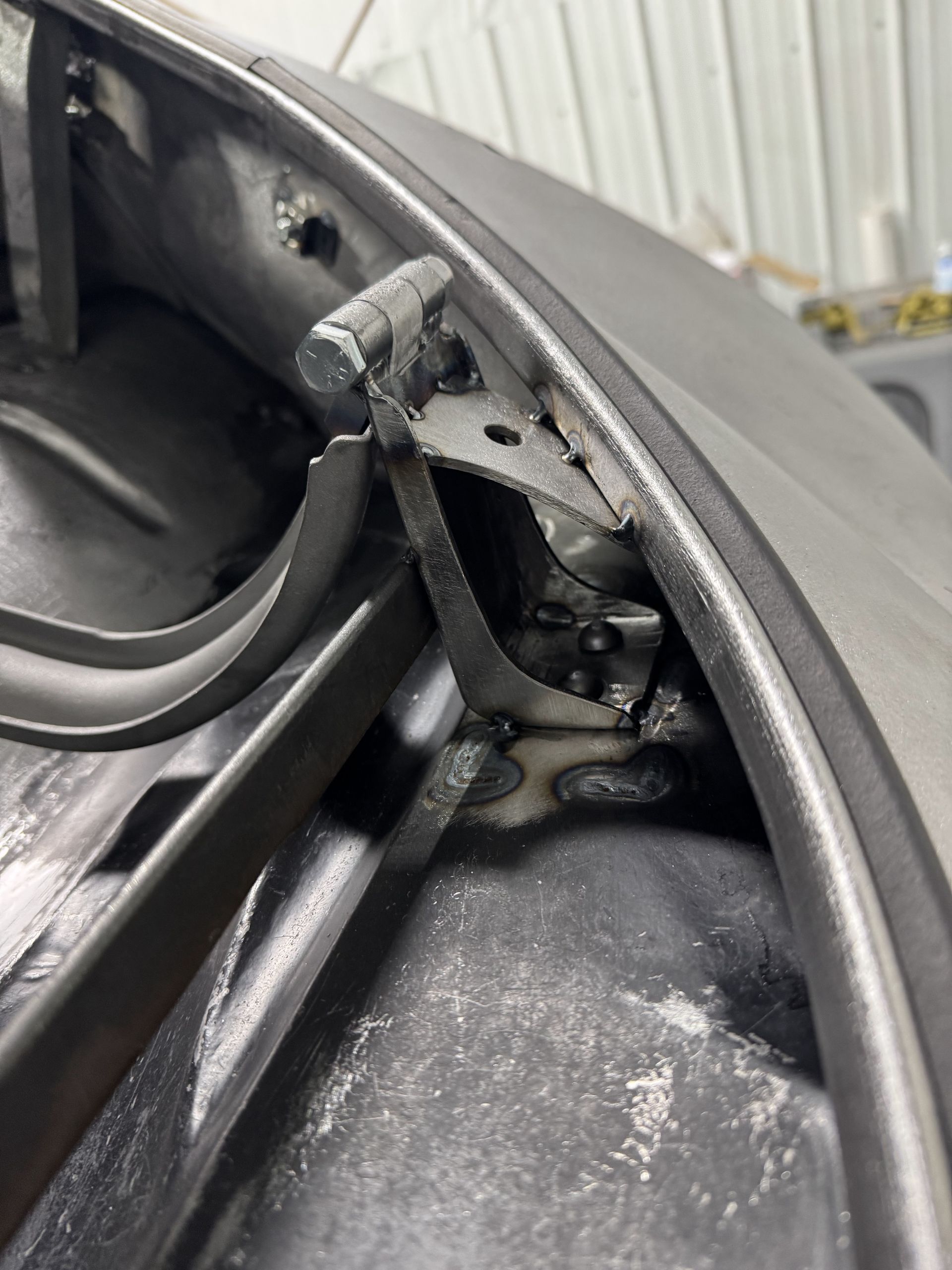 A close up of a door hinge on a car.