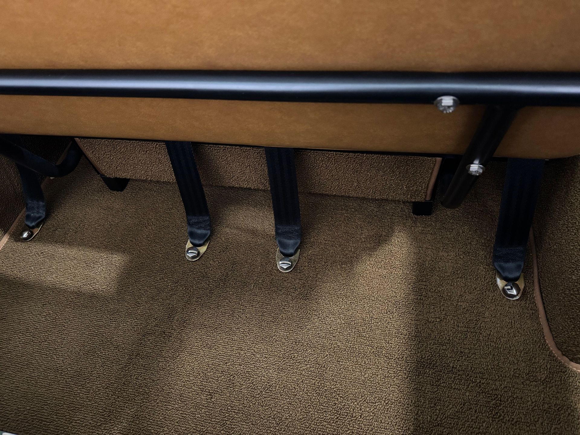 A close up of a carpeted floor with a couch in the background