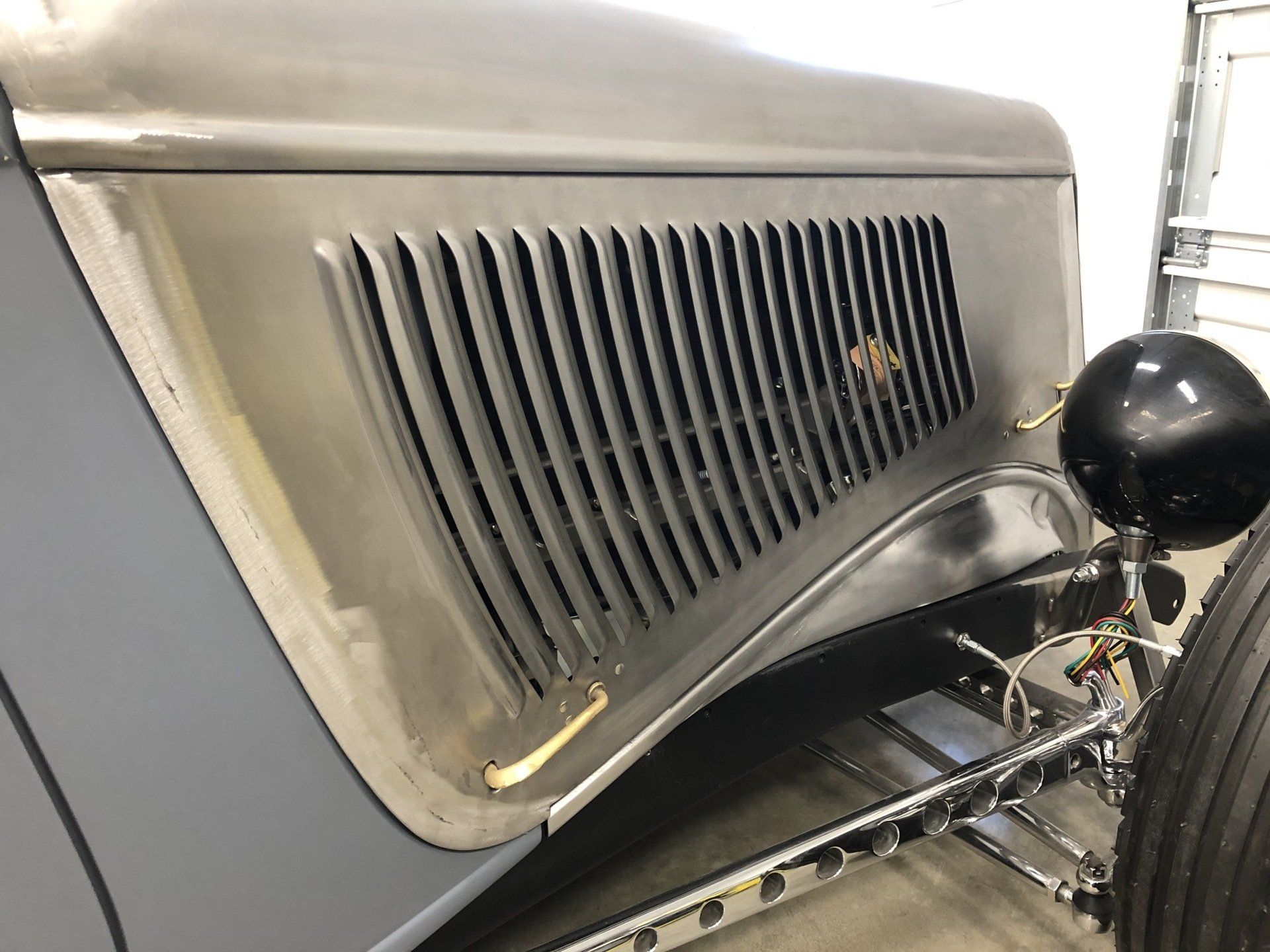 A close up of a car 's hood with a grille on it.
