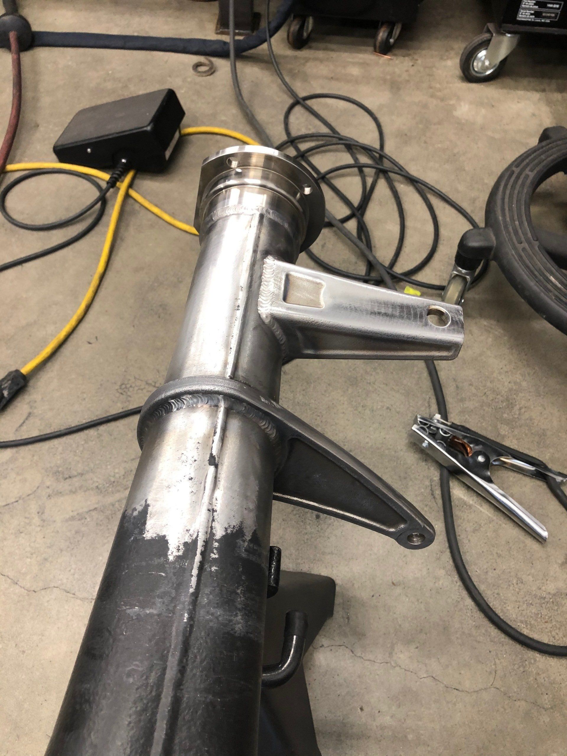 A piece of metal is being worked on in a garage