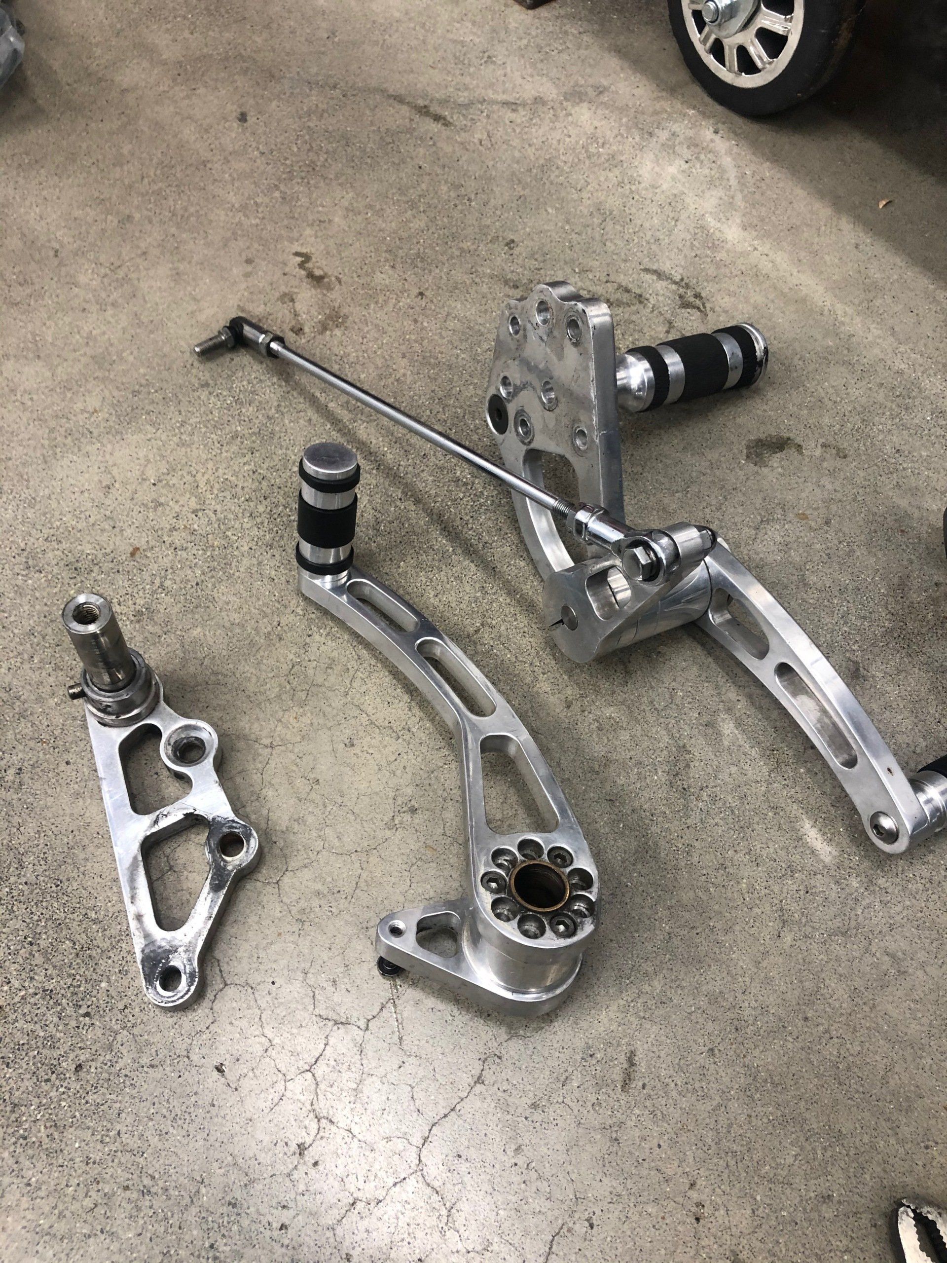 A set of motorcycle pedals are sitting on a concrete floor.