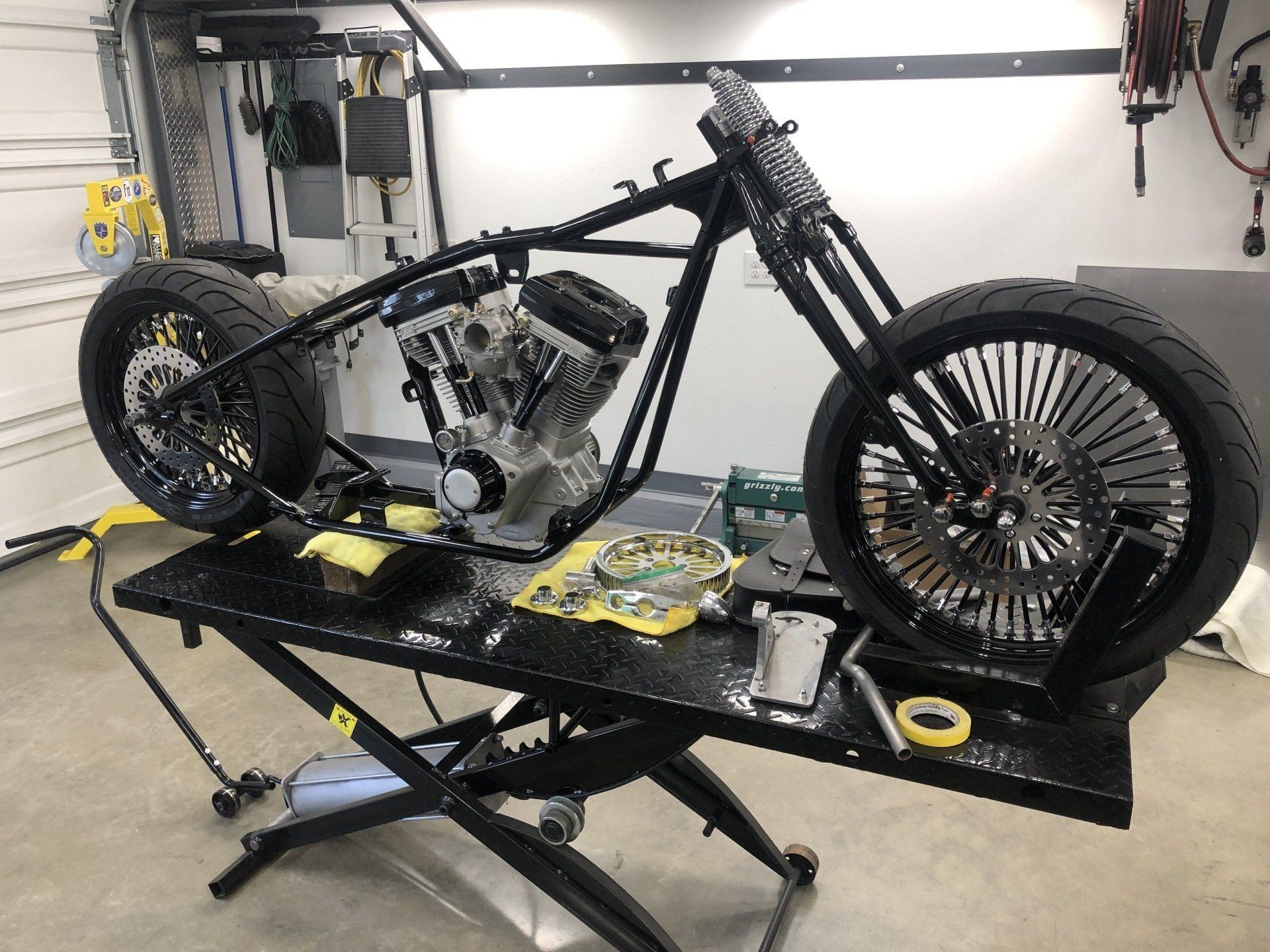 A motorcycle is sitting on a lift in a garage.