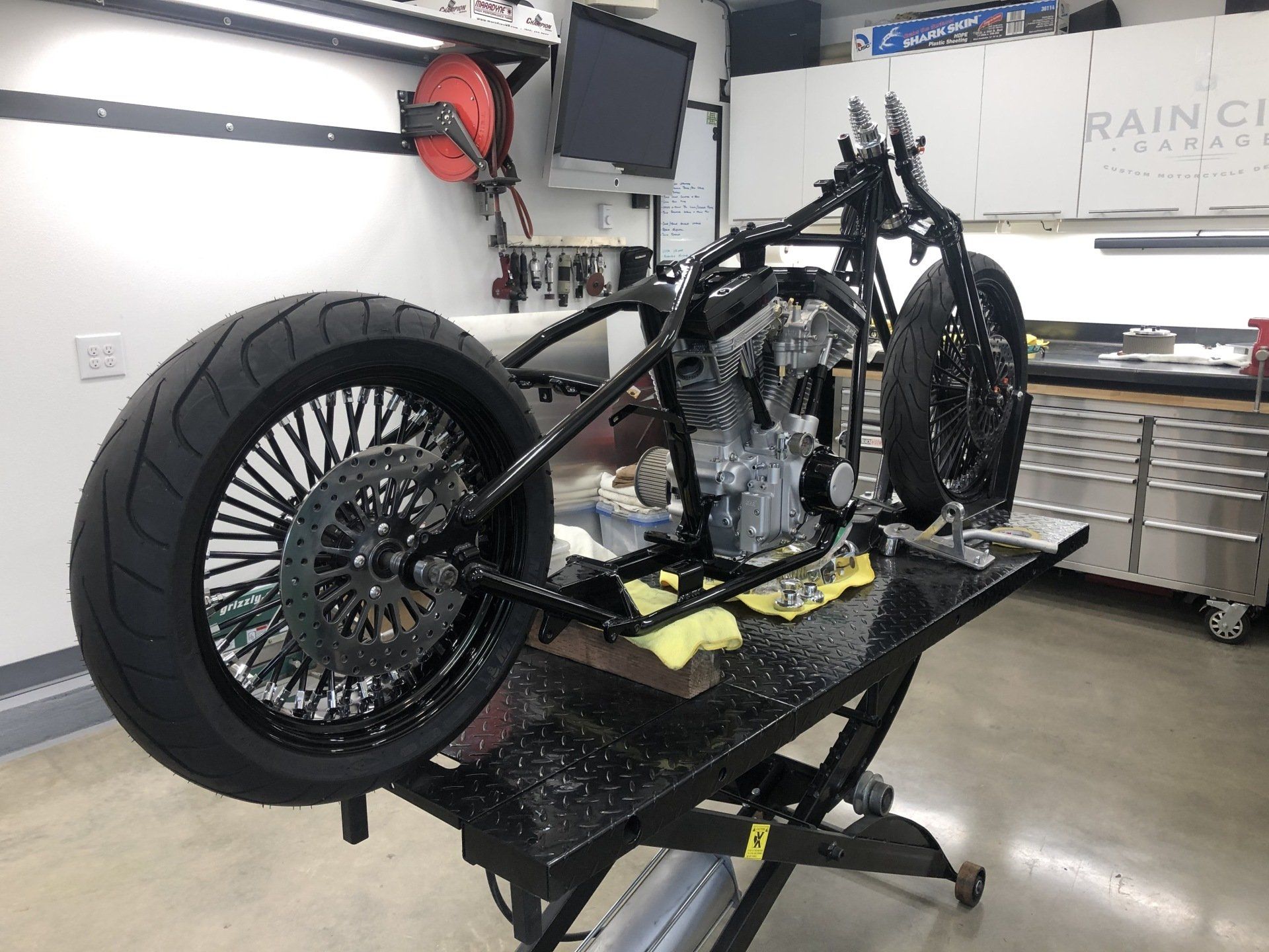 A motorcycle is sitting on a lift in a garage.