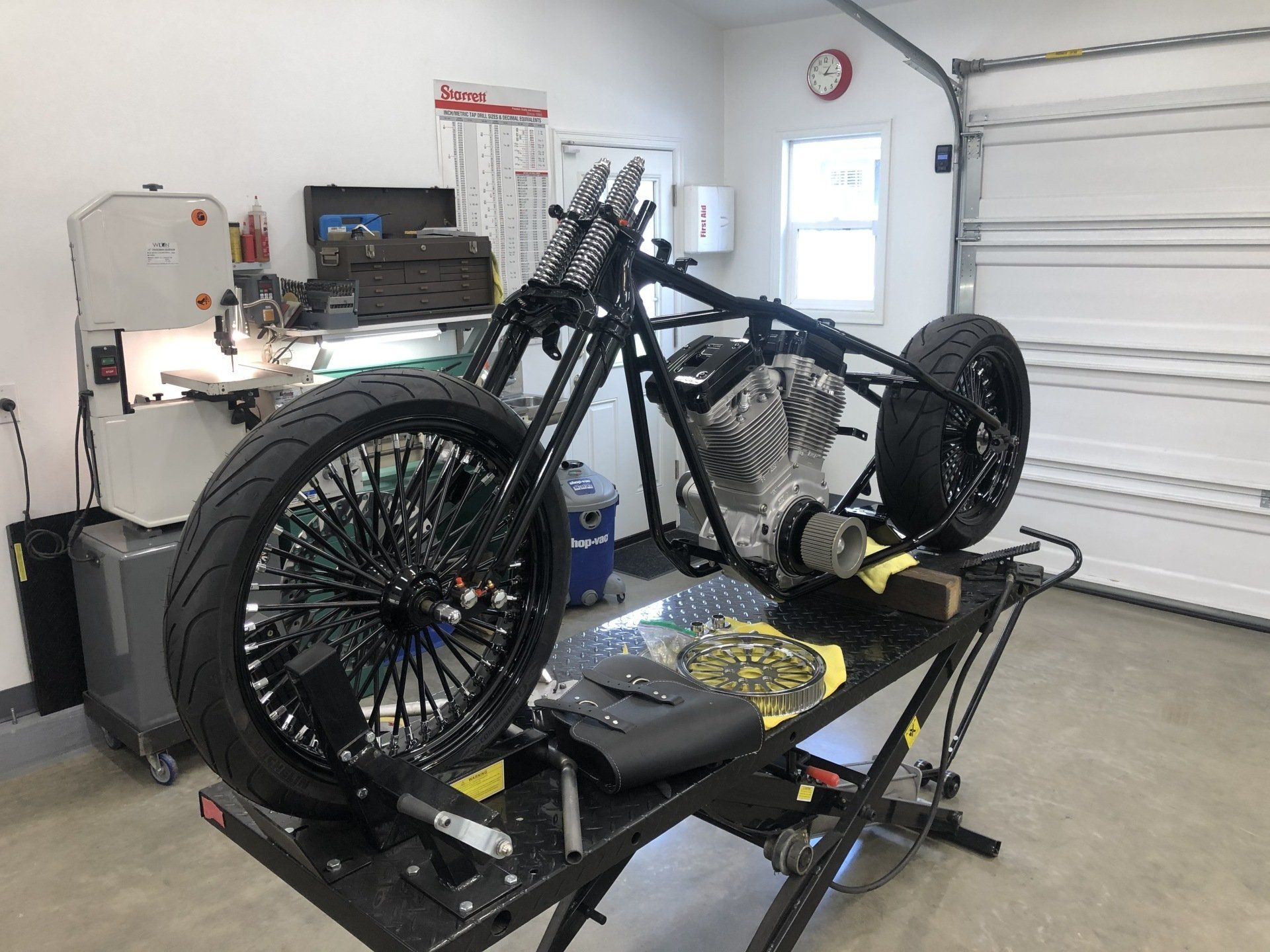 A motorcycle is sitting on a lift in a garage.