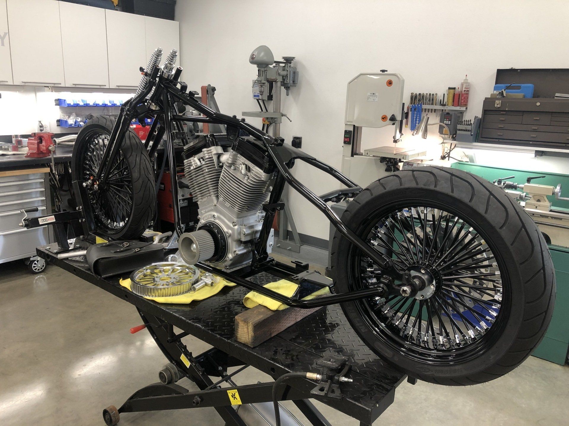 A motorcycle is sitting on a lift in a garage.