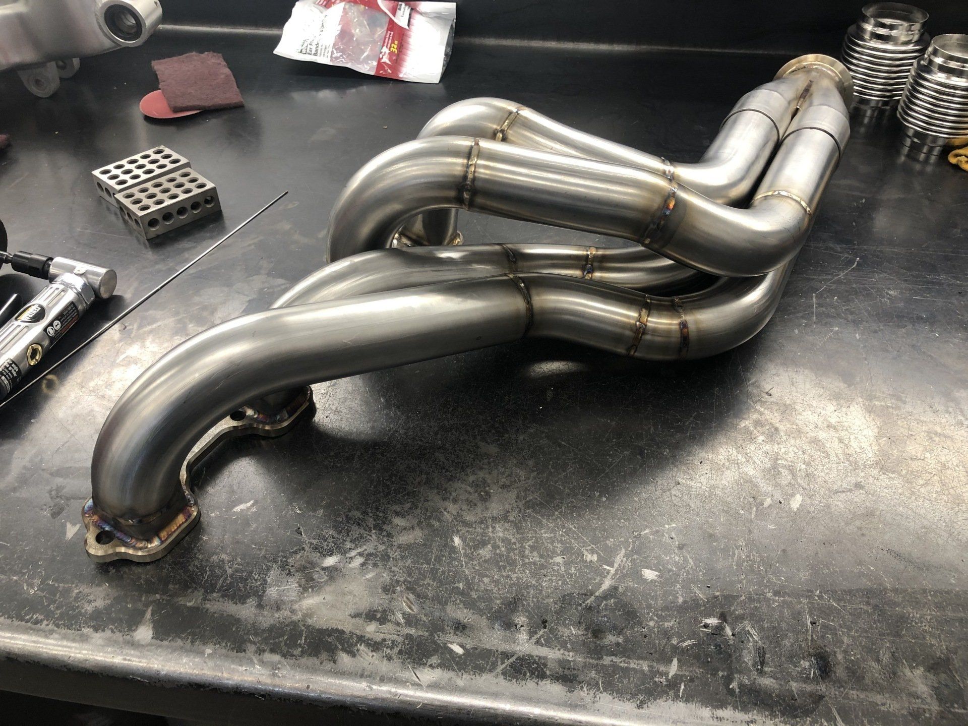 A stainless steel exhaust pipe is sitting on a table.