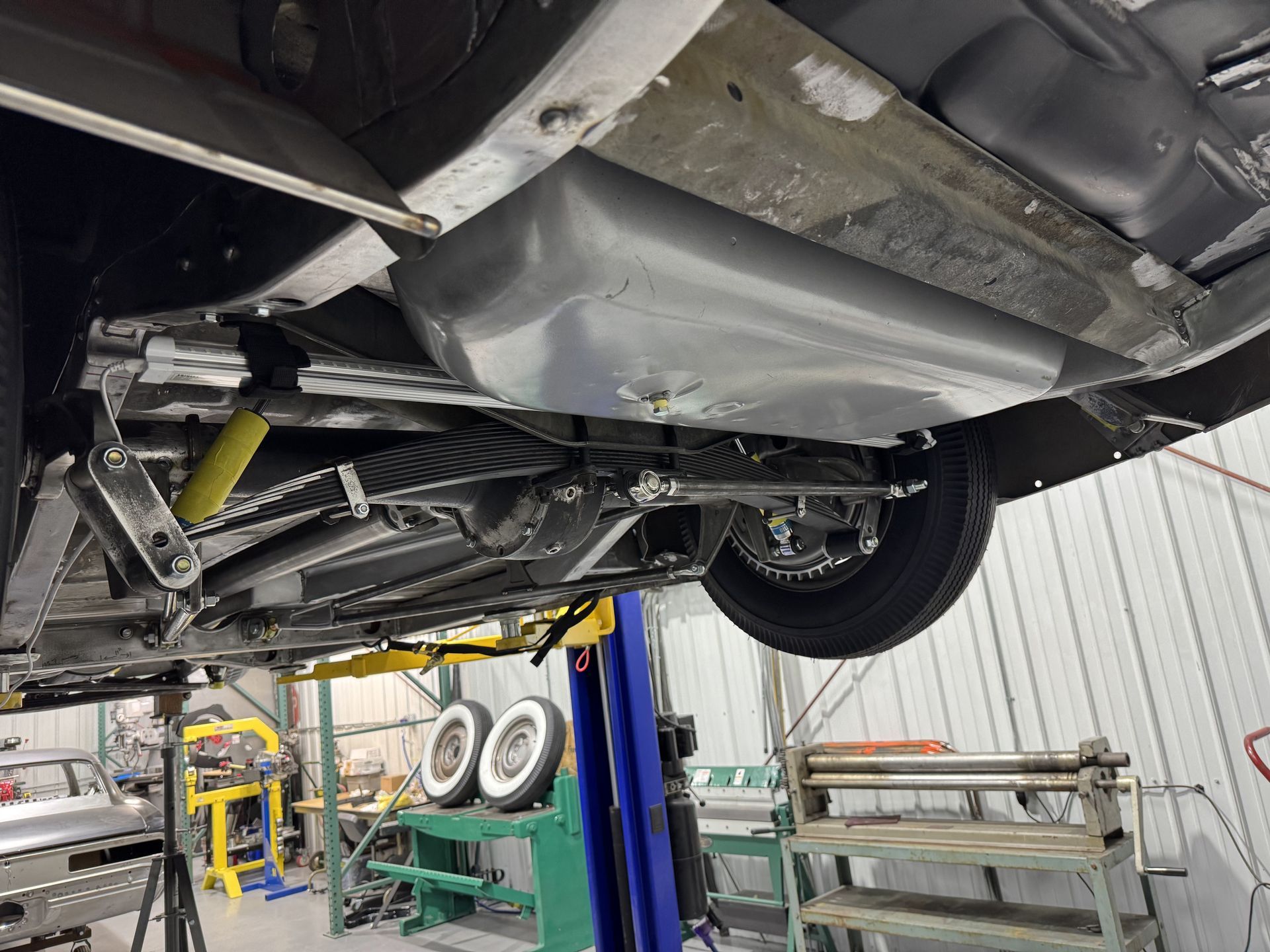 A car is sitting on a lift in a garage.