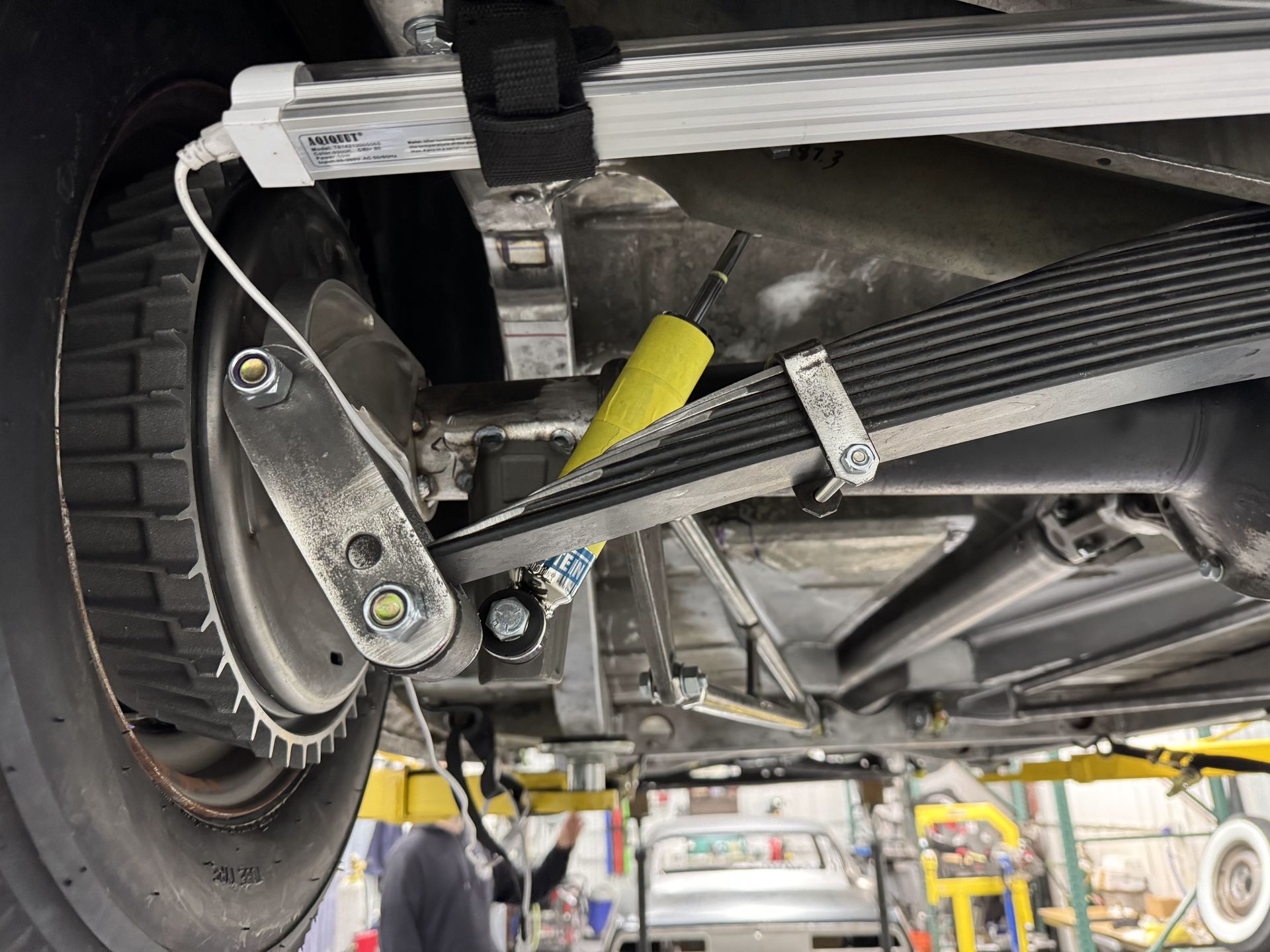 A close up of the underside of a car on a lift.