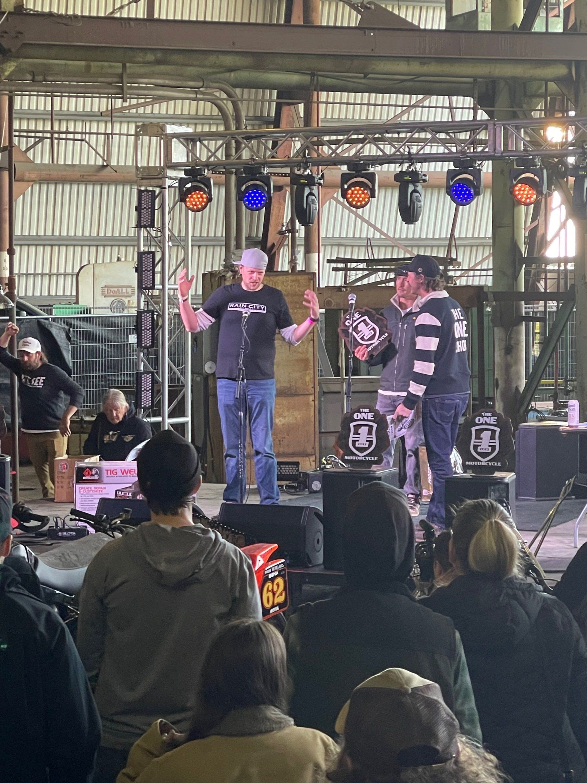 A man is standing on a stage giving a speech to a crowd of people.