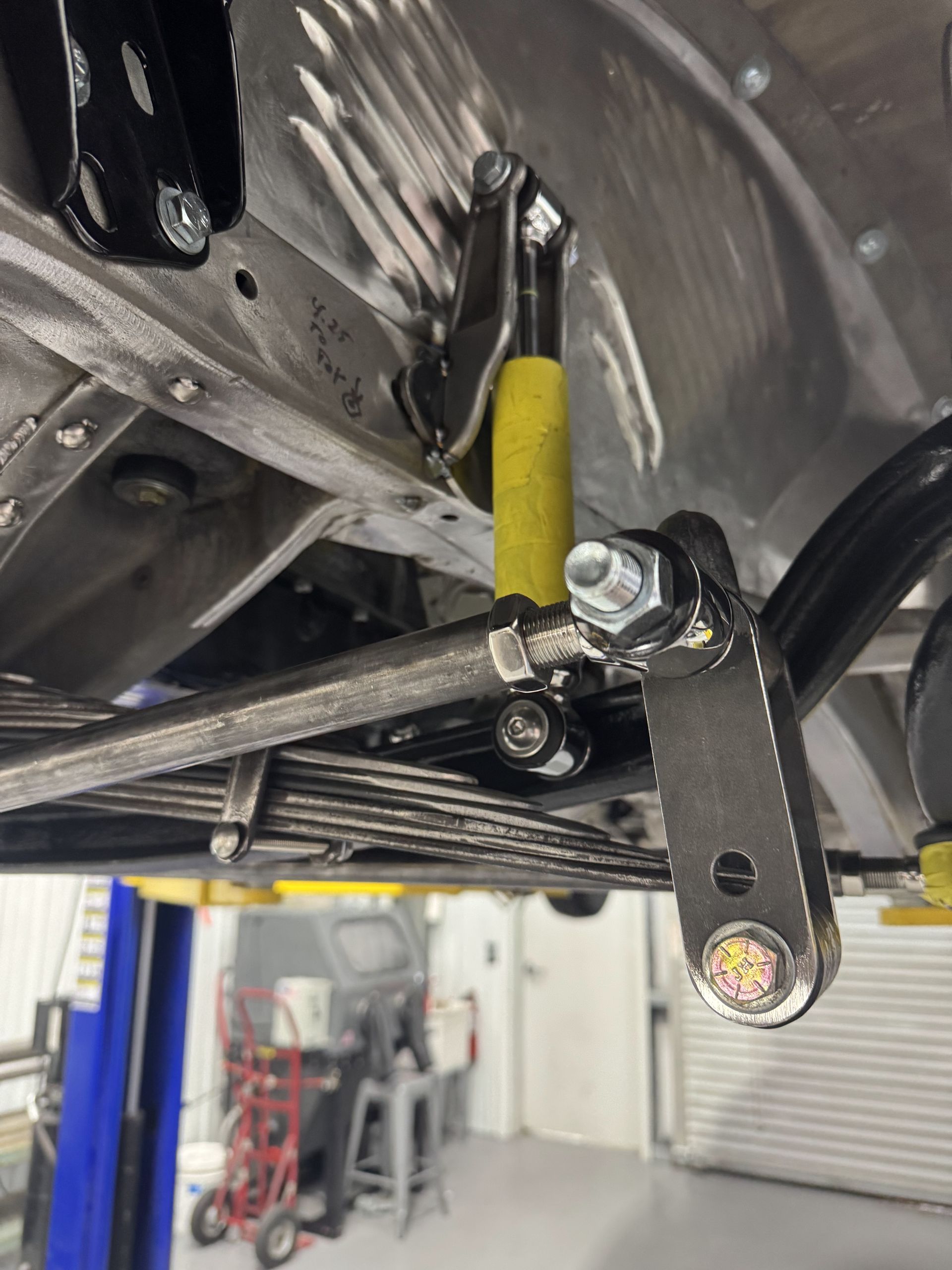 A car is sitting on a lift in a garage.