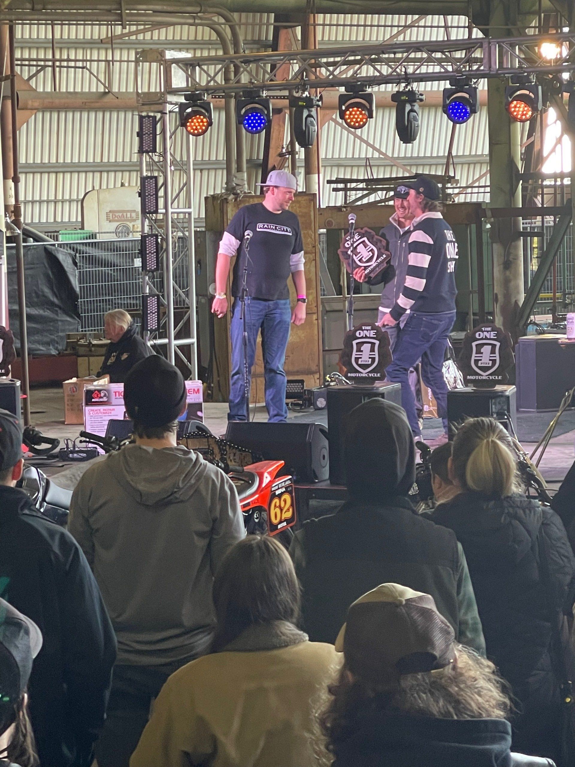 A group of people are sitting in front of a stage watching a band perform.