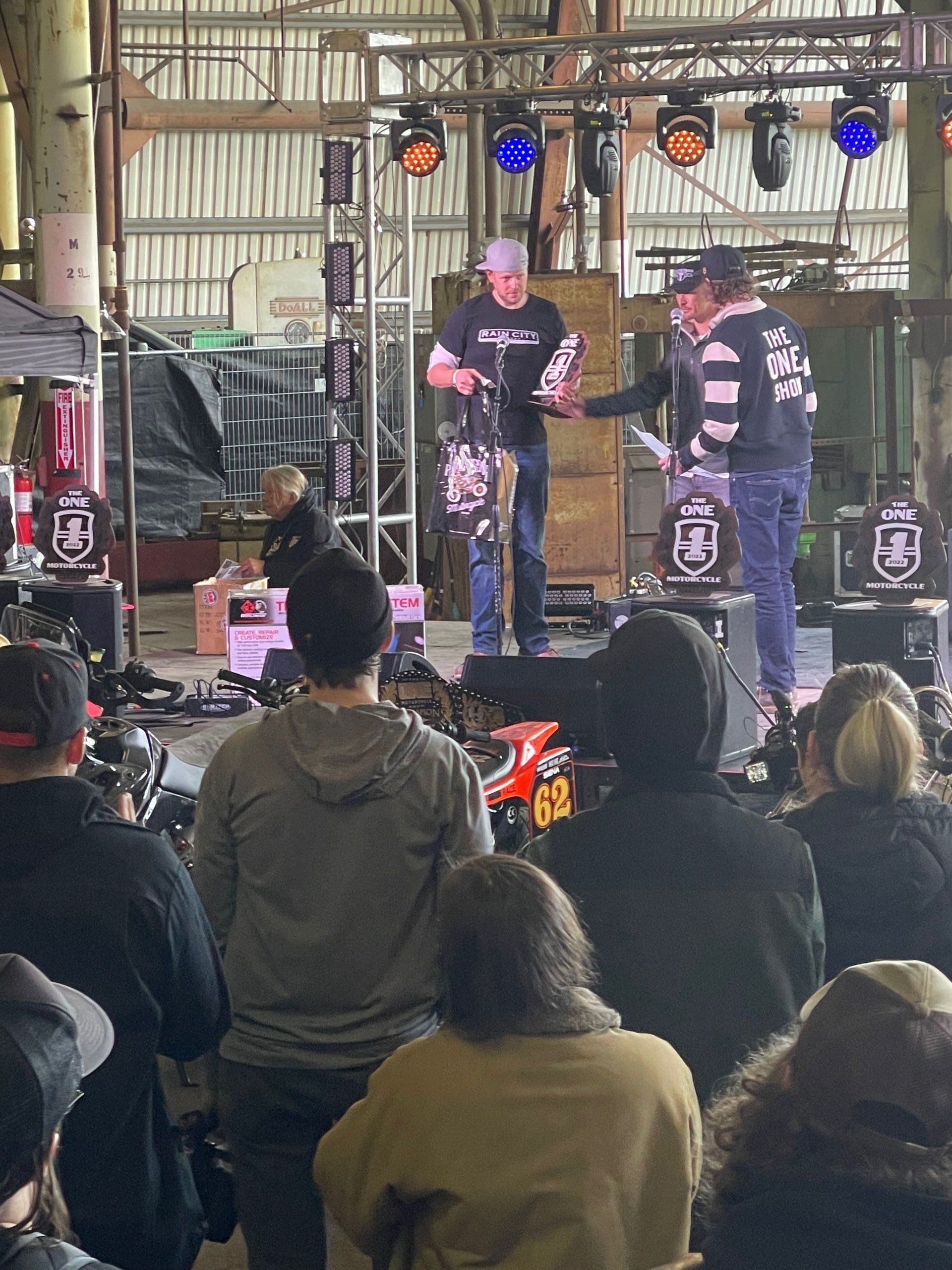 A group of people are sitting in front of a stage watching a band perform.