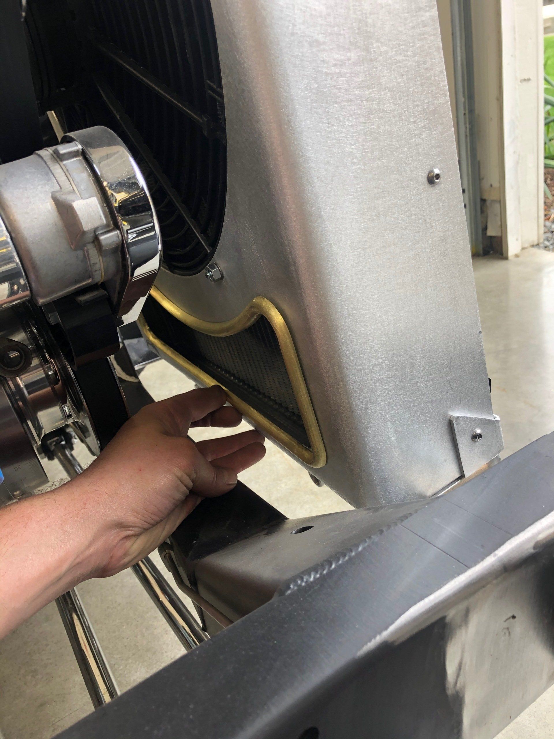 A person is working on a radiator on a car.