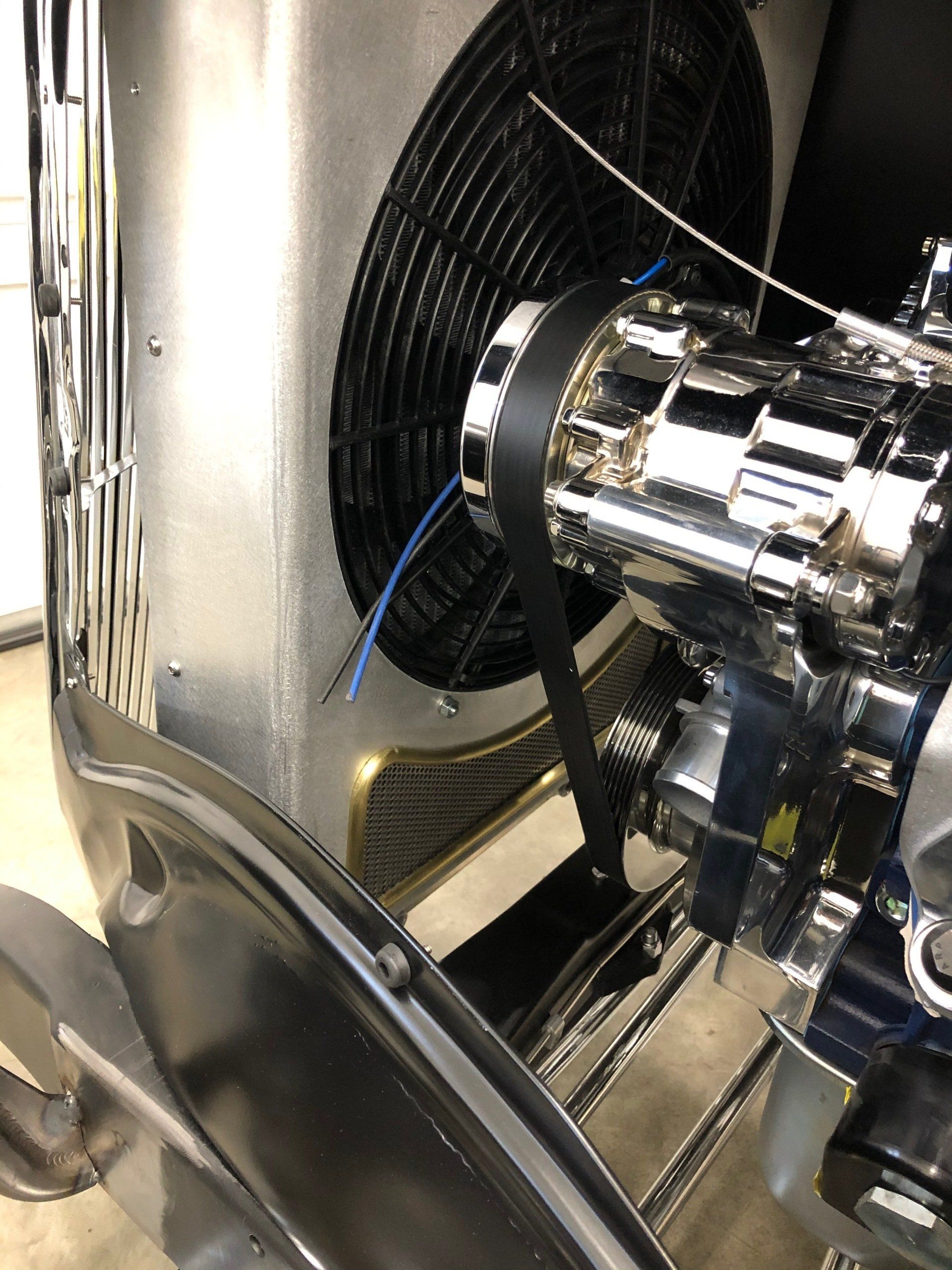 A close up of a car engine with a fan attached to it.